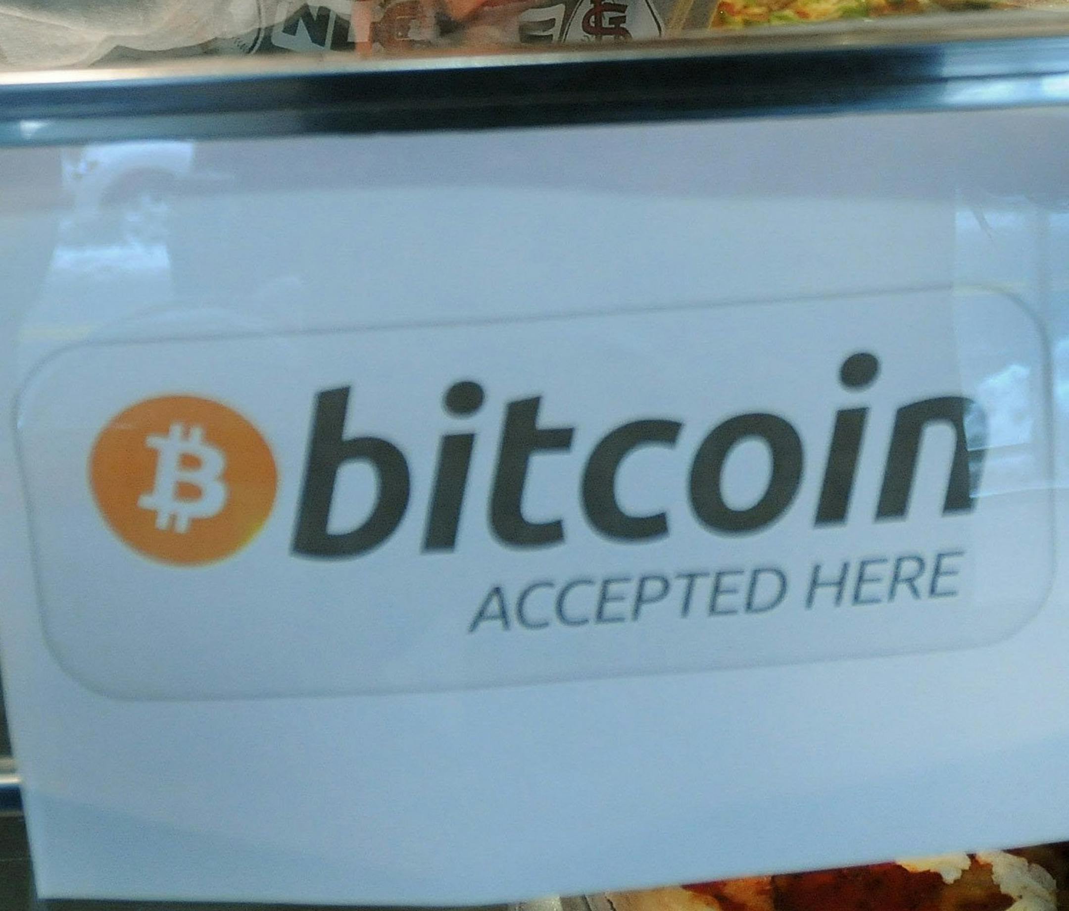 Steve Kalcanides, owner of Helen's Pizza in Jersey City, poses for a photo with a sign of bitcoin in his store in Jersey City, Feb. 5, 2014. (Mitsu Yasukawa/The Record/MCT) ORG XMIT: 1149306