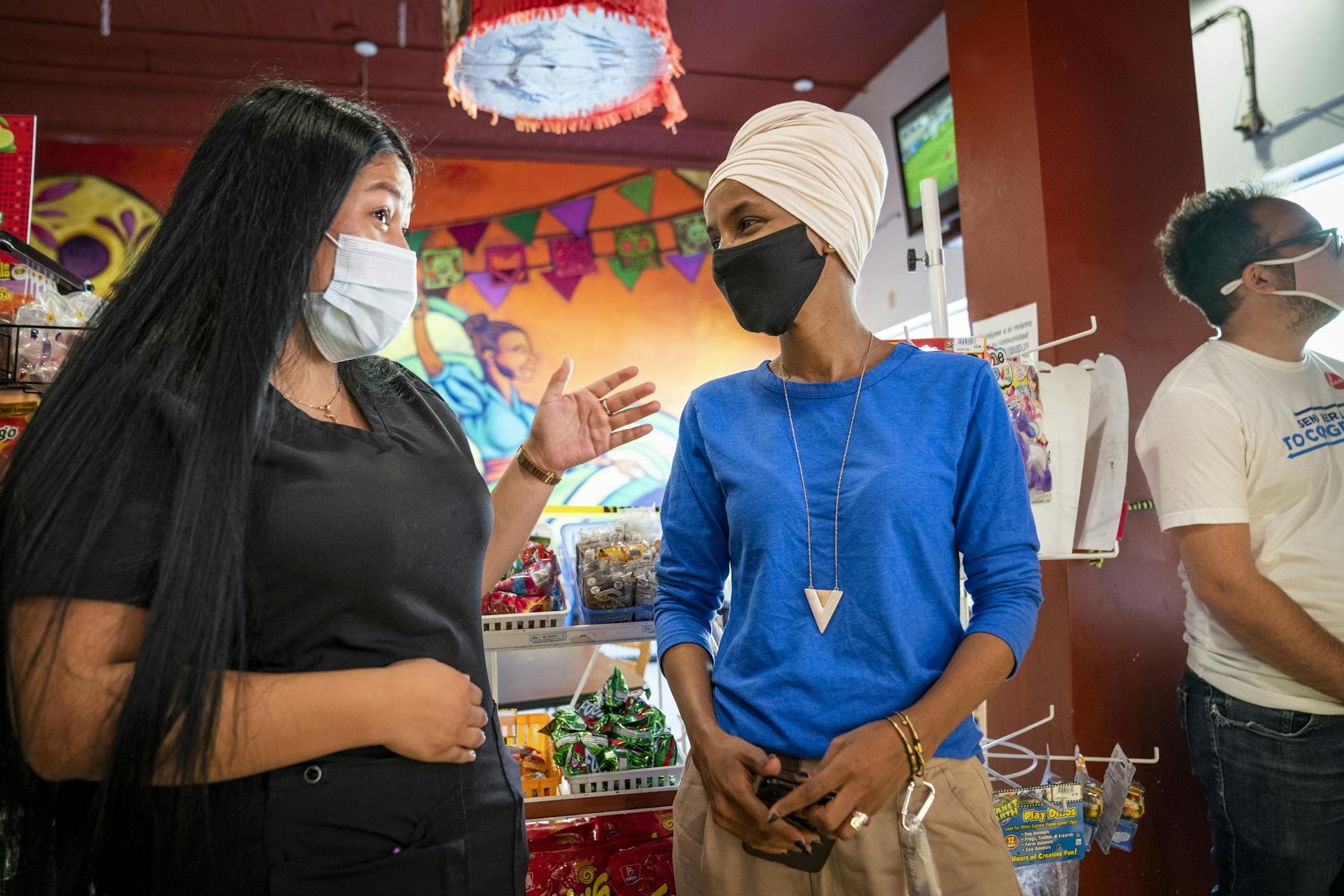 U.S. Rep. Ilhan Omar, right, talked with Dulce Sanchez, whose family owns Dulceria La Pinata at Mercado Central in Minneapolis, during a get out the vote stop on Primary Election Day.