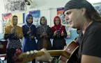 In this Tuesday, Aug. 9, 2016 photo, American musician Lanny Cordola, right, practices a Prince song with Afghan scouts at Physiotherapy and Rehabilit