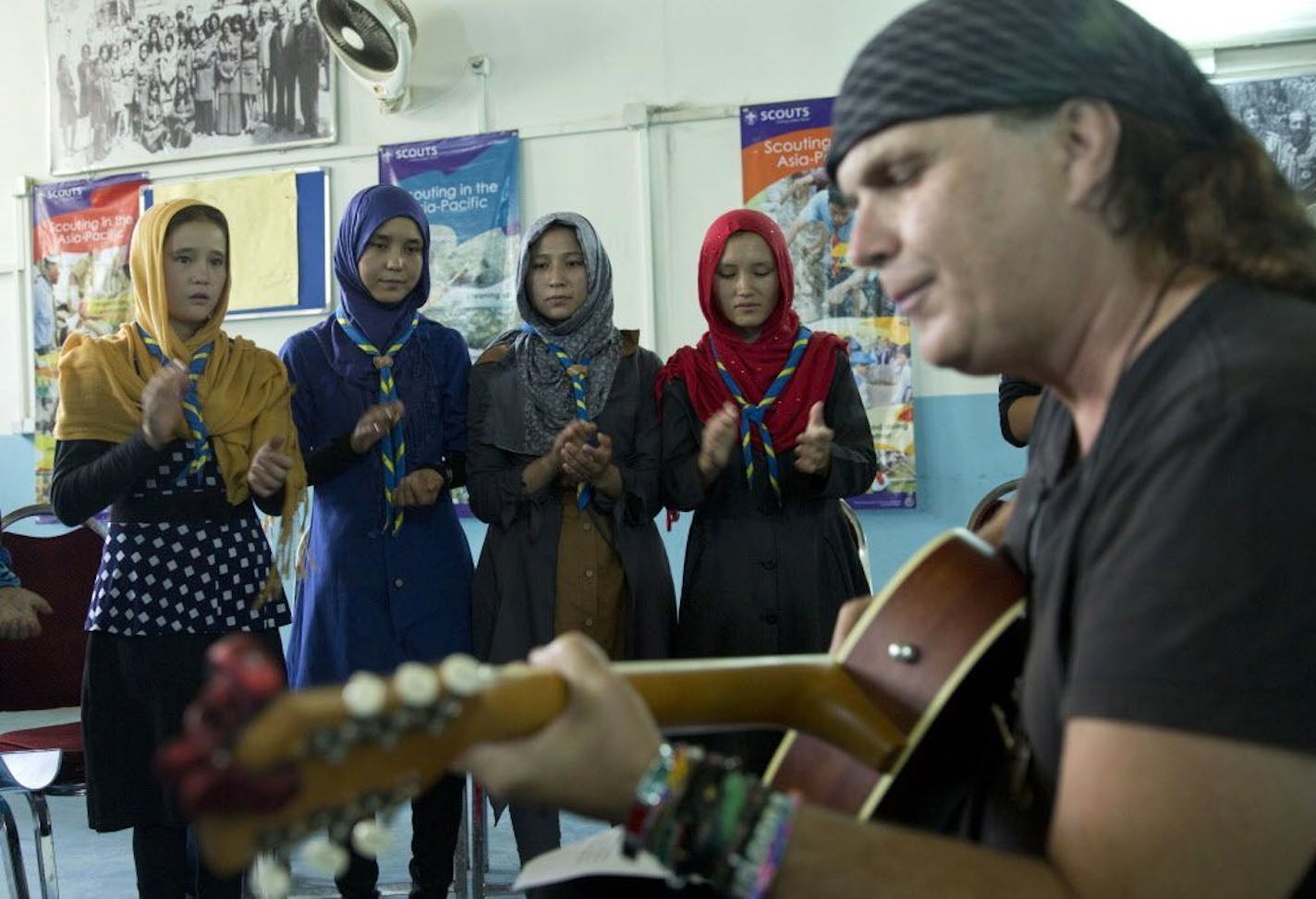 In this Tuesday, Aug. 9, 2016 photo, American musician Lanny Cordola, right, practices a Prince song with Afghan scouts at Physiotherapy and Rehabilitation Services for Afghanistan (Parsa) center in Kabul, Afghanistan. Parsa's Marni Gustavson's eyes brimmed with tears as she watched a dozen Afghan children learning the words to Prince's "Purple Rain." Prince, before his death, was a major donor to the NGO.