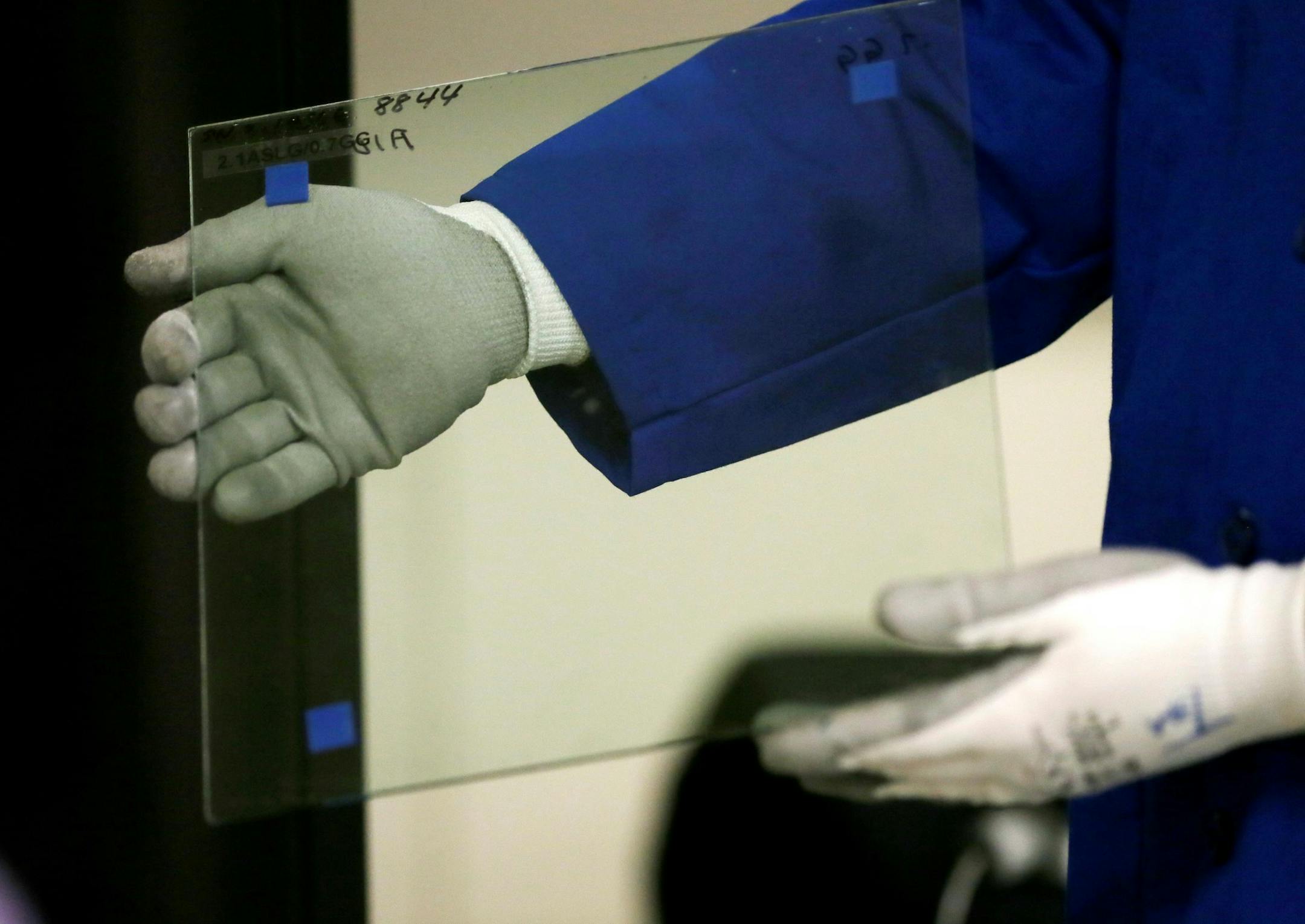 In a photo from Dec. 14, 2015, Tim Huten, Corning mechanical engineer holds a small sample of Corning Gorilla Glass after it was hit by an ice ball at the Dearborn Development Center in Dearborn, Mich. Gorilla Glass is found on billions of mobile phones and an automotive version will be used for the windshield and engine cover of the new Ford GT sports car. Ford says the glass is more durable and scratch-resistant than traditional glass. Itís also about 30 percent lighter, which saves fuel