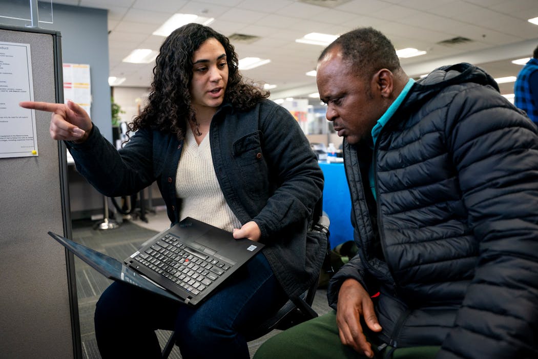UPS talent recruiter Kiaira Fletcher-Toney helps Cephas Awudzi with his UPS job application at a job fair at the CareerForce Center on Wednesday in Minneapolis.