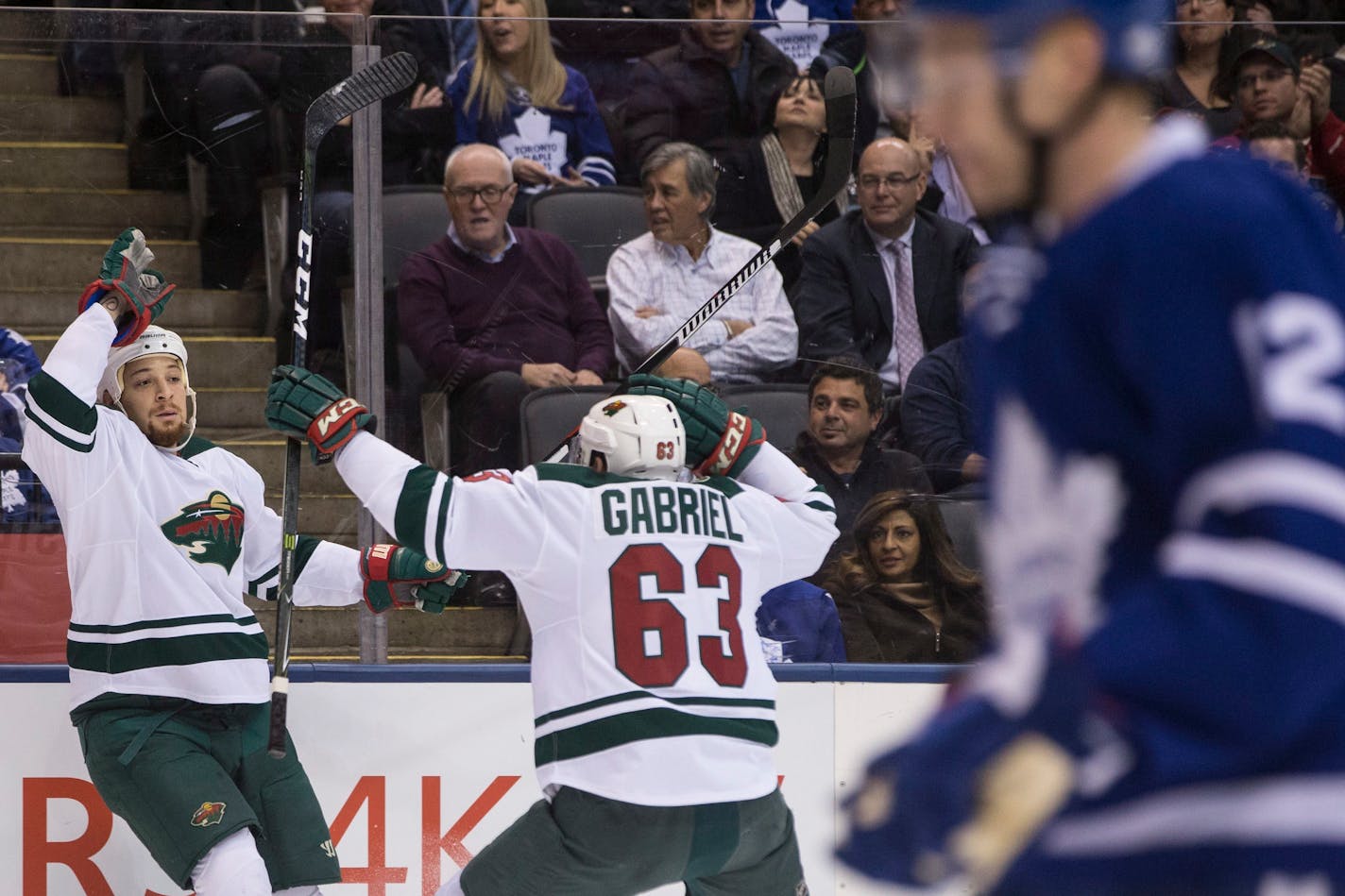 Wild right wing Chris Stewart, left, celebrates his goal with teammate Kurtis Gabriel as Maple Leafs defenseman Matt Hunwick skates by during the first period Wednesday.