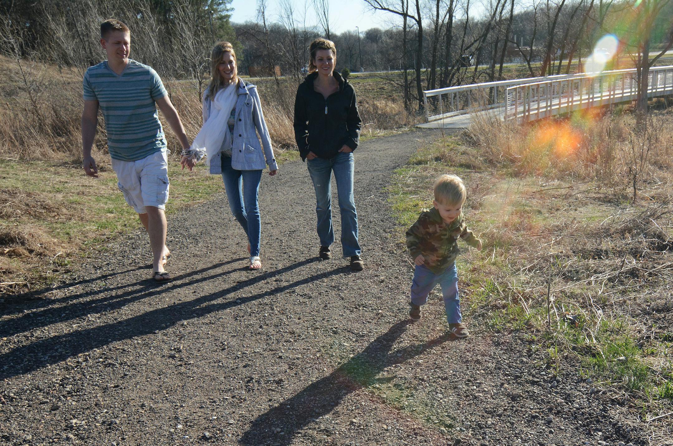 (left to right) Jonathan and Reseth Oberg, of Omaha, Leah Bailey, of Scandia, and Titus Oberg, 1, of Omaha, walked along a trail at Lebanon Hills. This week, volunteers will clean along the trails in honor of Earth Day. Photo by Liz Rolfsmeier, Special to the Star Tribune