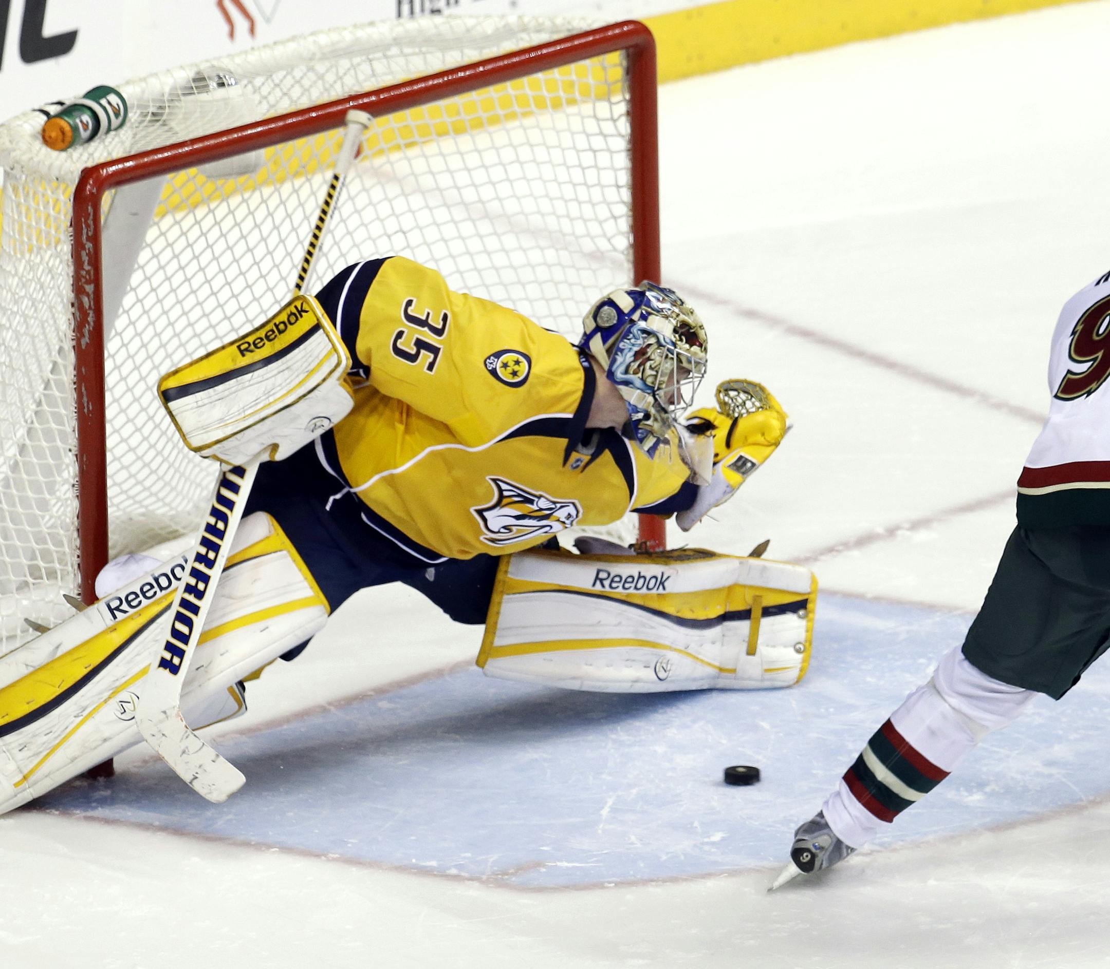 Minnesota Wild center Mikko Koivu (9), of Finland, scores against Nashville Predators goalie Pekka Rinne (35), of Finland, during a shootout at an NHL hockey game on Saturday, March 9, 2013, in Nashville, Tenn. The Wild won the shootout to win the game 2-1. (AP Photo/Mark Humphrey)