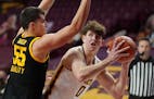 Minnesota center Liam Robbins eyed the basket as Iowa center Luka Garza defended in the first half Dec. 25. 