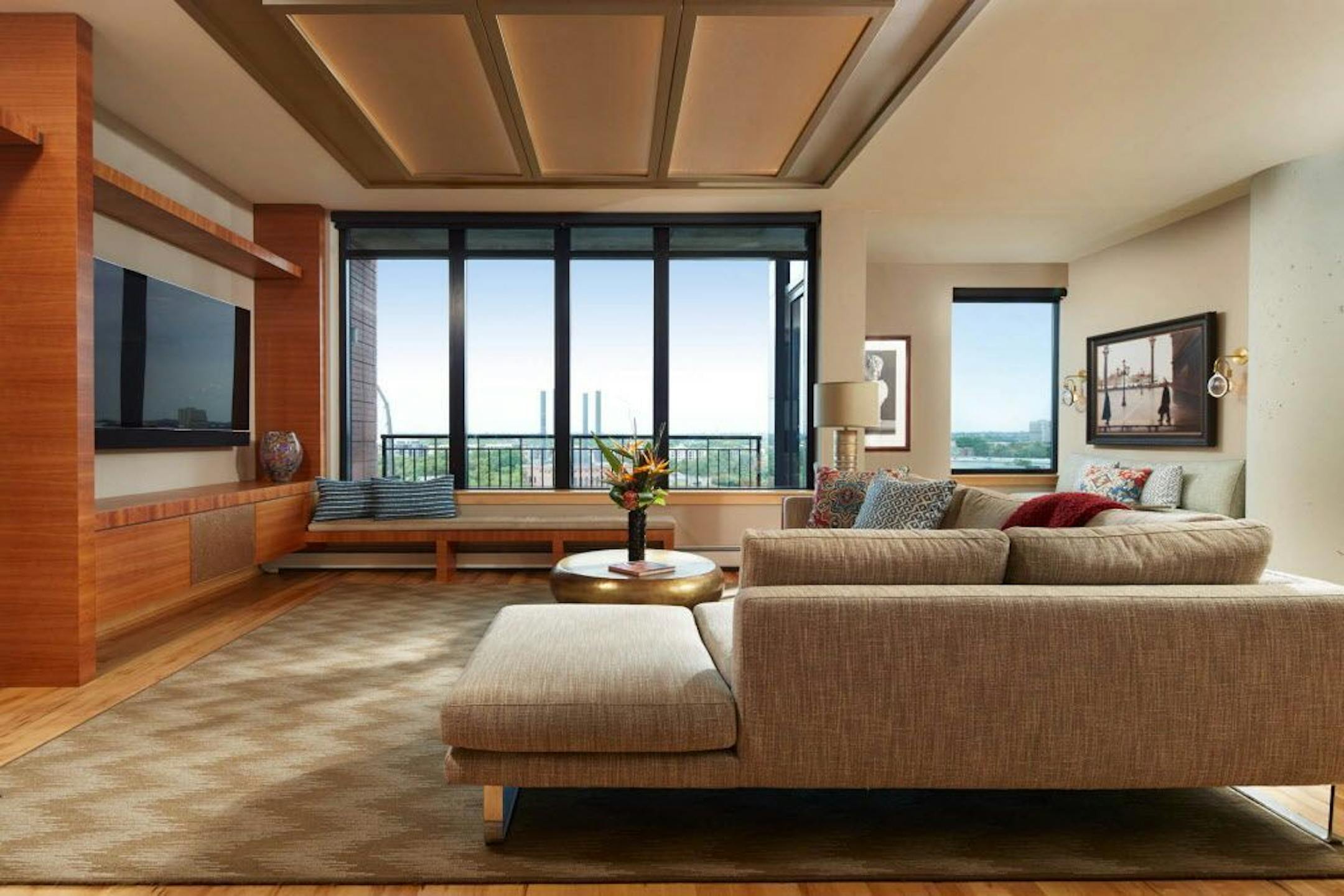 The Bridgewater condo's refreshed interiors features a quartered cherry veneer media cabinet, window bench and custom-built ceiling boxes to define the living room, designed by Lilu Interiors.