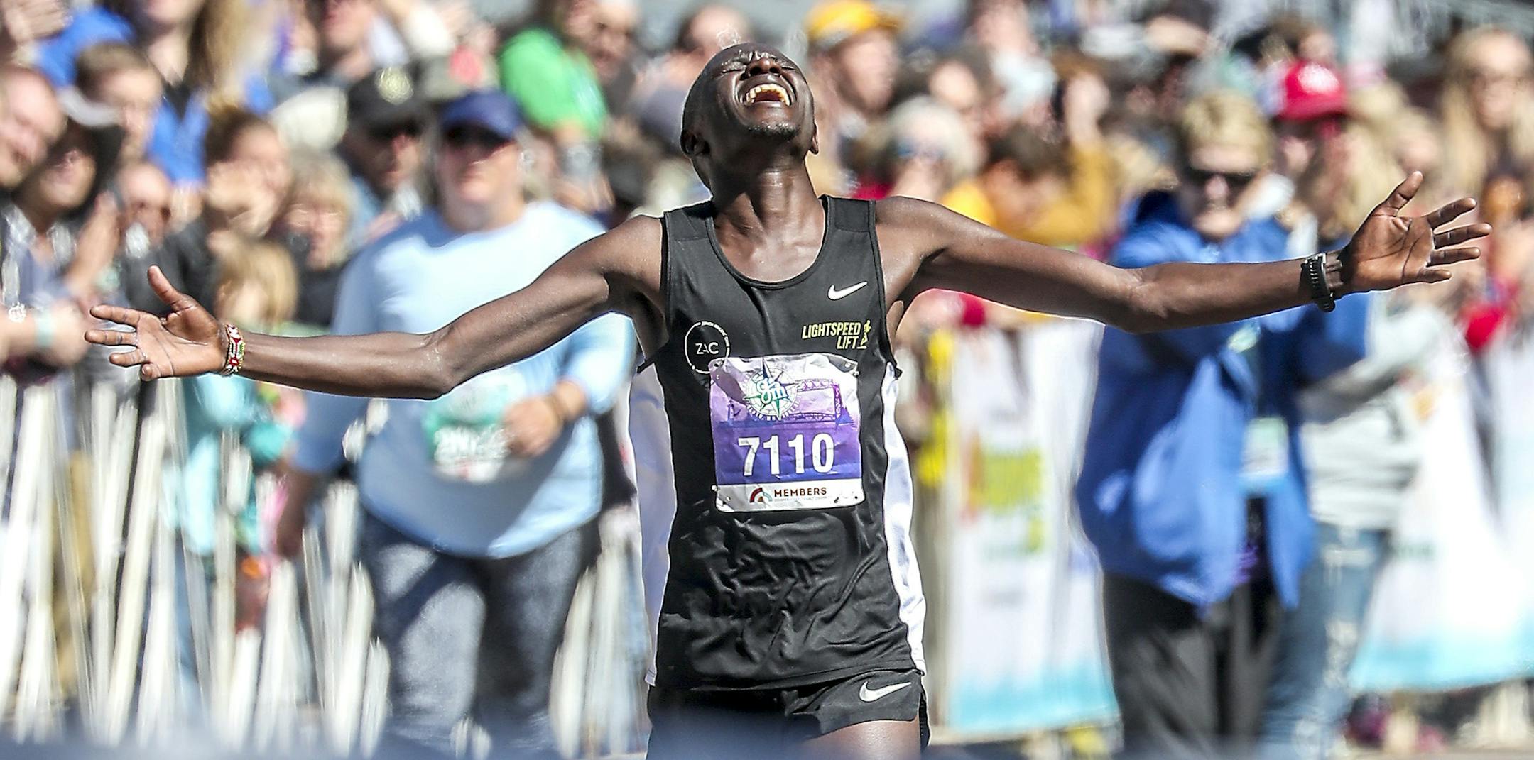 Boniface Kongin of Duluth celebrates Saturday at the finish line area of Grandma's Marathon in Duluth. Kongin won with a time 2:11:56.