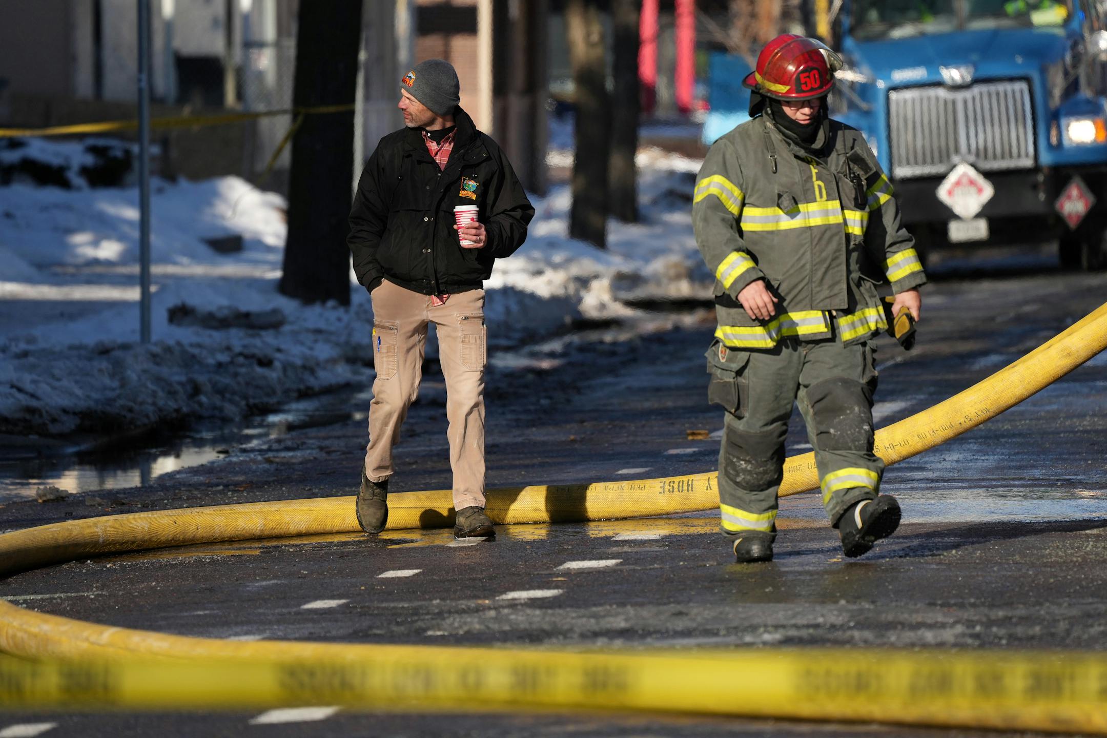 A member of the State Fire Marshal's office and Minneapolis fire fighters look over the scene of a building fire Saturday, Dec. 3, 2022 in the 2300 block of Lyndale Avenue South in Minneapolis.