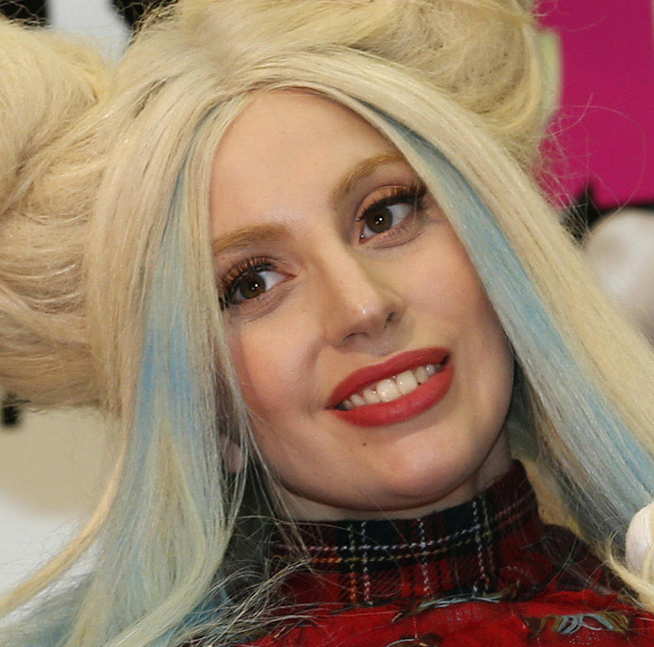 FILE - In this Dec. 1, 2013 file photo, Lady Gaga poses for photographers with a Lady Gaga version of Hello Kitty doll during a press conference to promote her latest album in Tokyo. When she came to life in 1974, she was a kitty without a name, sitting sideways in blue overalls and a big red bow, on a coin purse for Japanese girls. On Saturday, Nov. 1, 2014, fans around the world celebrate the 40th anniversary of this global icon of "cute-cool." That is, Hello Kitty. Hello Kitty is featured on