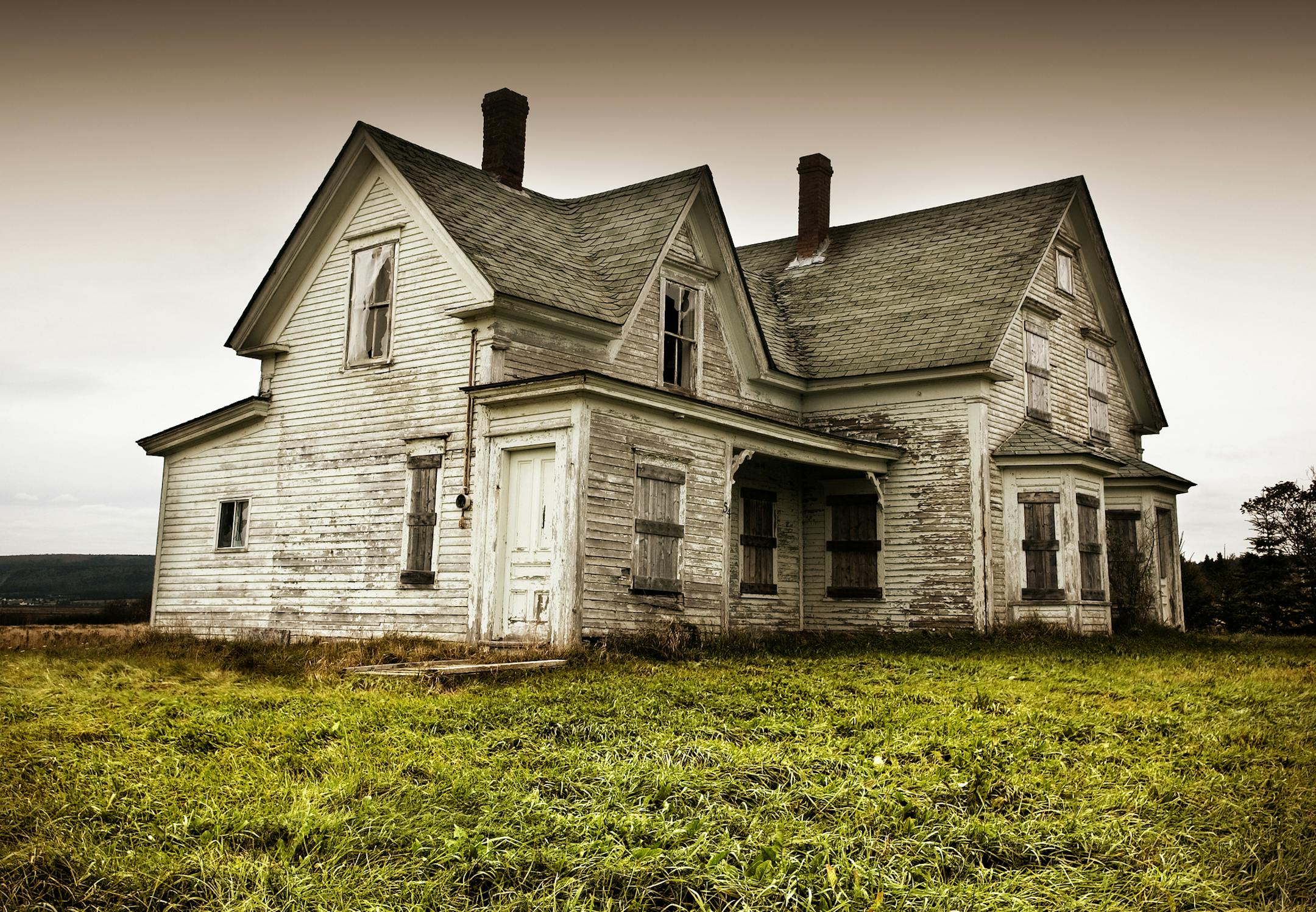 An old abandoned home sitting in a field.