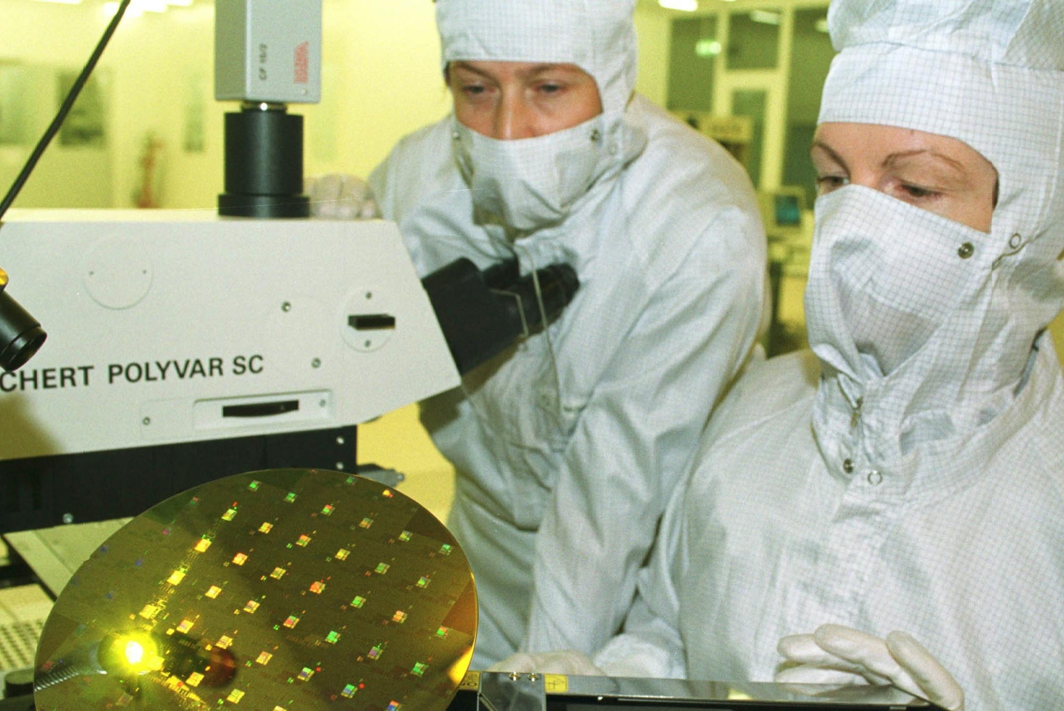 Two employees of the Institute of Semiconductor Physics (IHP) supervise the clean room of the IHP, the work process on an 8-inch wafer loader, on 15 December 1999 in Frankfurt. The construction of the IHP will be inaugurated on 20 December 1999. The cost for the construction amounted to 128 million DM. Kernstueck is the clean room, which was handed over in September. With the clean room, the IHP is to become one of the most modern microelectronics research institutions in the world. Here also th