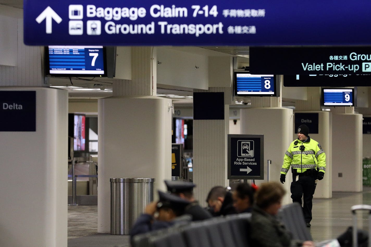 A police officer patrolled the baggage claim area Saturday.