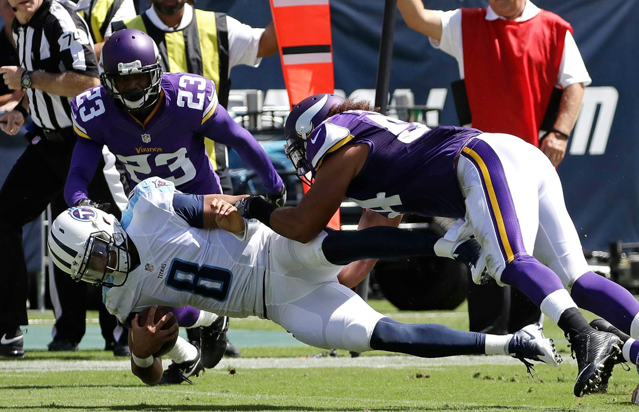 Tennessee Titans quarterback Marcus Mariota (8) is brought down by Minnesota Vikings defenders Eric Kendricks (54) and Terence Newman (23)