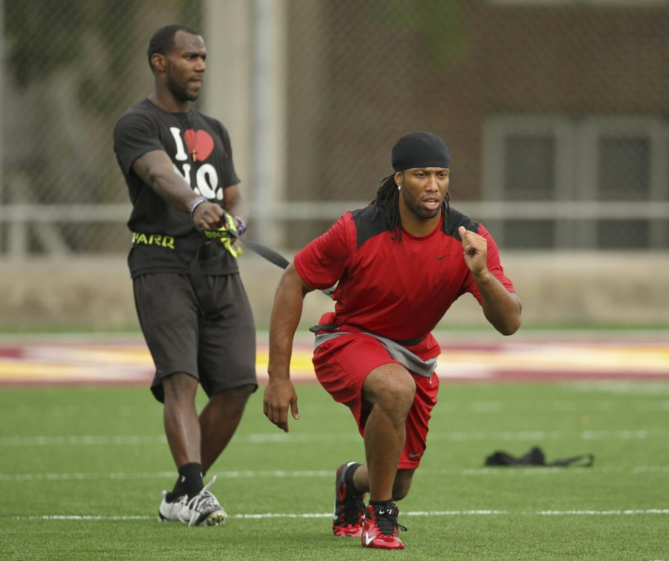 Arizona Cardinals wide receiver Larry Fitzgerald pulled against the resistance of a strap held by New Orleans Saints cornerback Malcolm Jenkins during their workout at the Gibson/Nagurski Football Complex on Monday. Fitzgerald and Bill Welle of Welle Fast Elite Sports Training have hosted workouts for NFL players for the past four years in the Twin Cities.