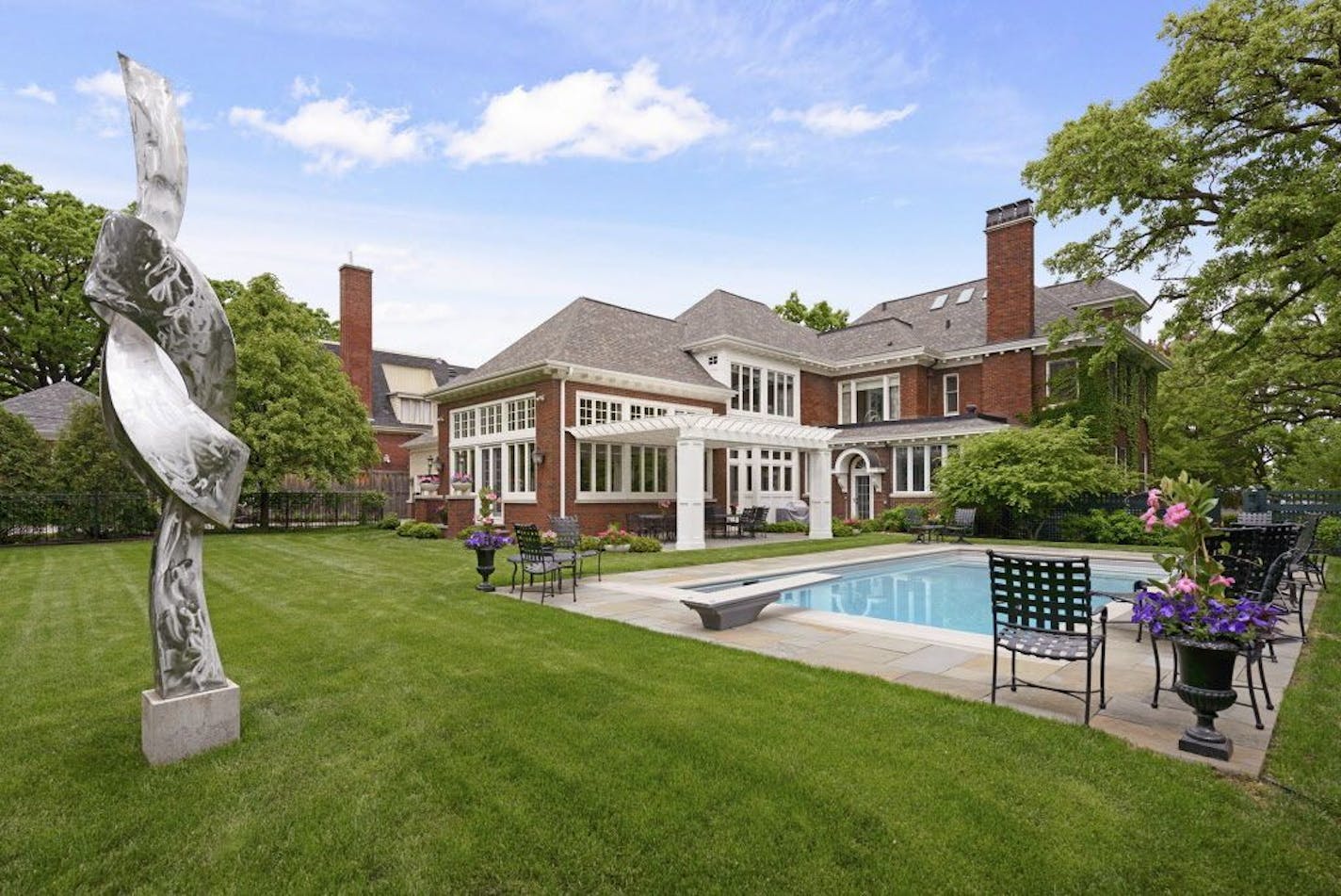 Back-yard swimming pool, patio, pergola, and metal sculpture.