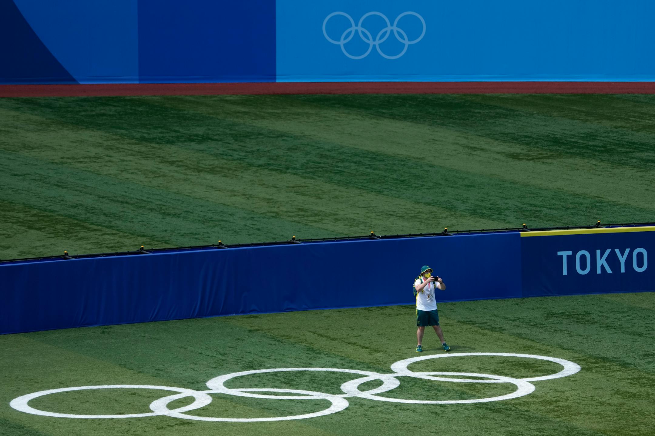 A member of Australia's women's softball team takes a photo in the outfield before practice for the 2020 Summer Olympics, Saturday, July 17, 2021, at Yokohama Baseball Stadium in Yokohama, Japan. (AP Photo/Charlie Riedel)