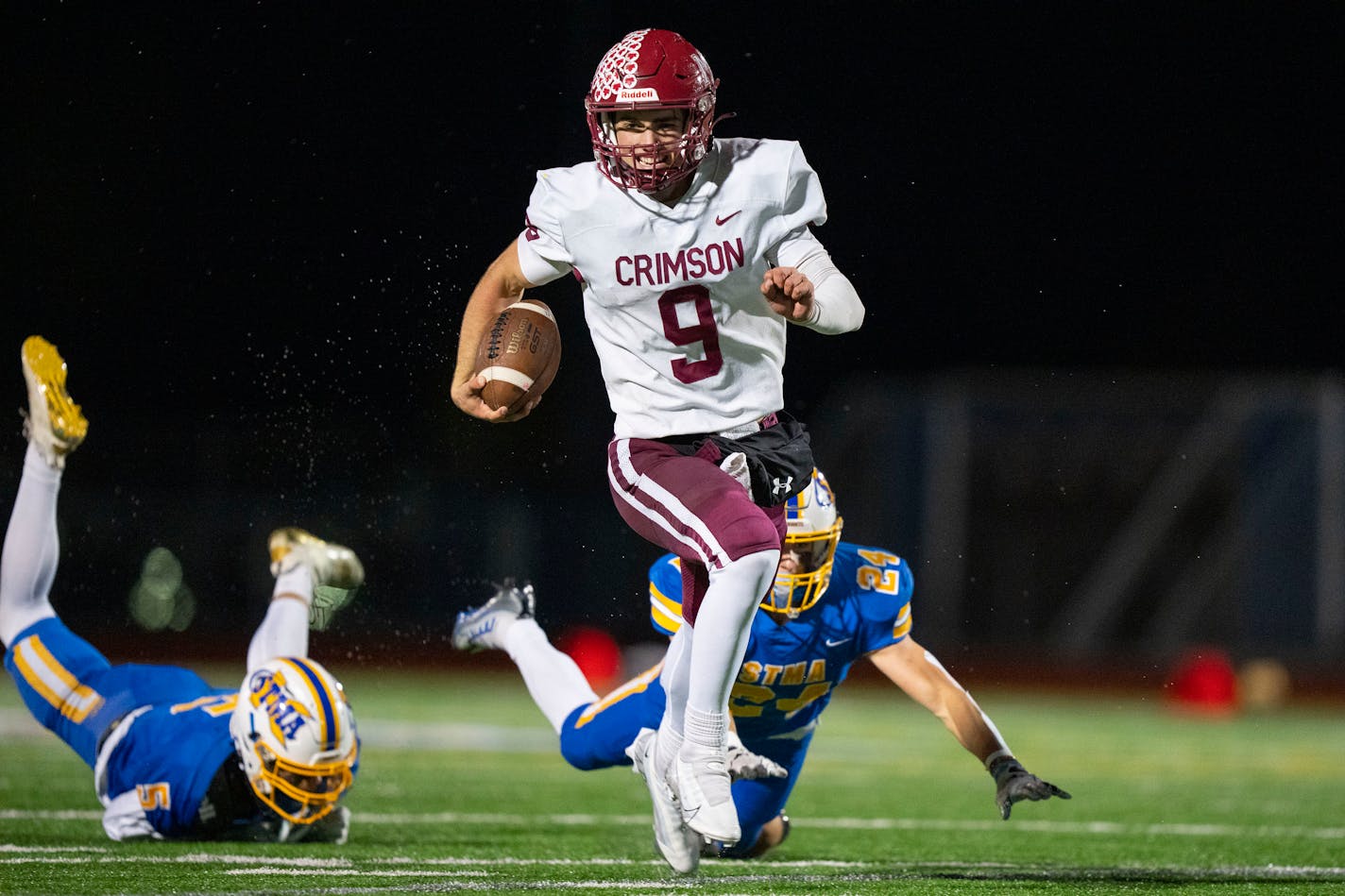 Maple Grove quarterback Jacob Kilzer (9) evades tackle attempts by St. Michael-Albertville defensive back Ryan Luster (5) and linebacker Zach Purcell (24) on the way to scoring a touchdown in the second quarter Friday, Oct. 14, 2022 at St. Michael-Albertville High School in St. Michael, Minn. ]