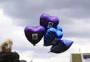 A woman holds balloons with photos of Alfie Evans, outside Alder Hey Children's Hospital, following the death of the 23-month old who was being treate
