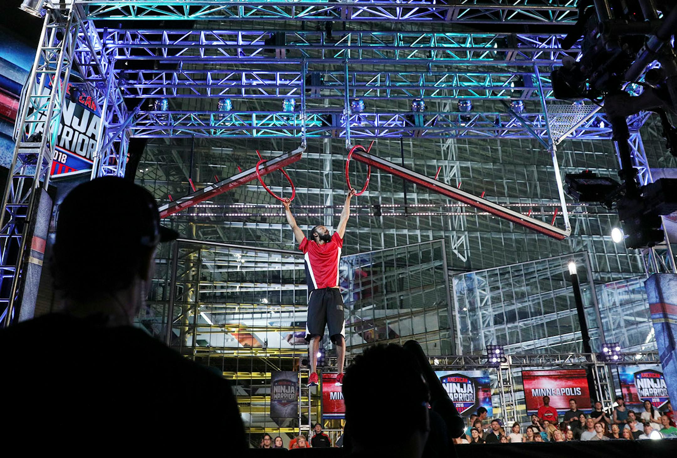 Audience members watched as a contestant worked on the rings portion of the course.