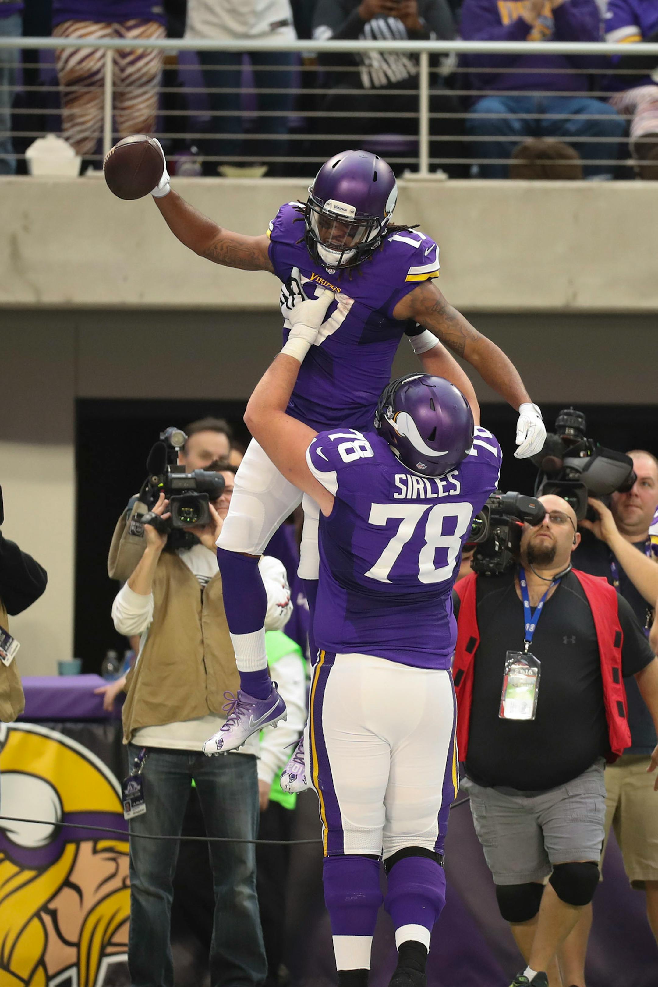 Vikings offensive tackle Jeremiah Sirles (78) hoisted Vikings wide receiver Jarius Wright (17) aloft after Wright caught a one yard touchdown pass in the second quarter.