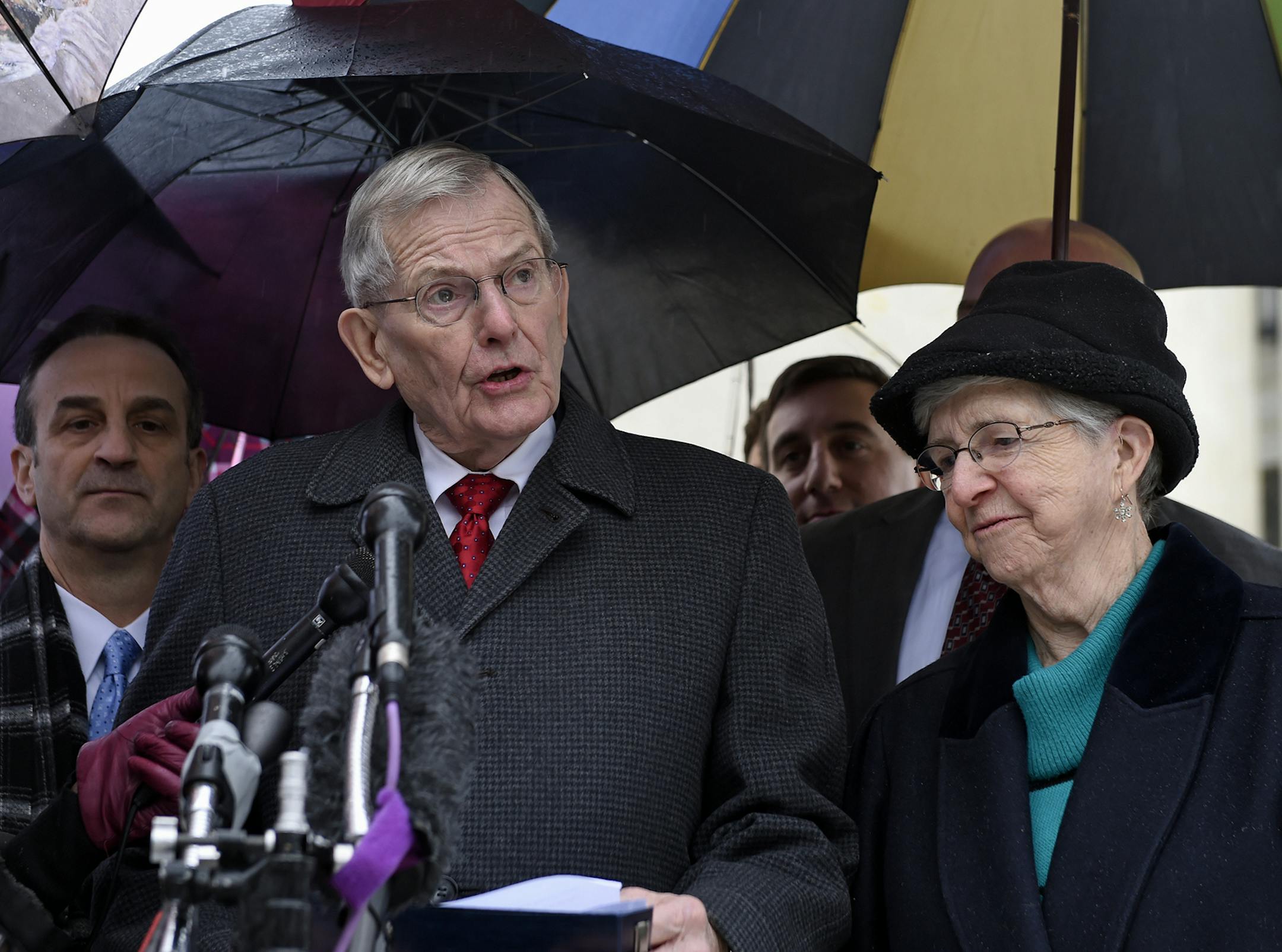 Good News Community Church Pastor Clyde Reed, center, accompanied by his wife Ann, talks to reporters outside the Supreme Court in Washington, Monday, Jan. 12, 2015. The Supreme Court appears likely to side with a small church in its fight with a Phoenix suburb over limits on roadside signs directing people to Sunday services. Liberal and conservative justices expressed misgivings Monday with the Gilbert, Arizona, sign ordinance because it places more restrictions on the churches' temporary sign