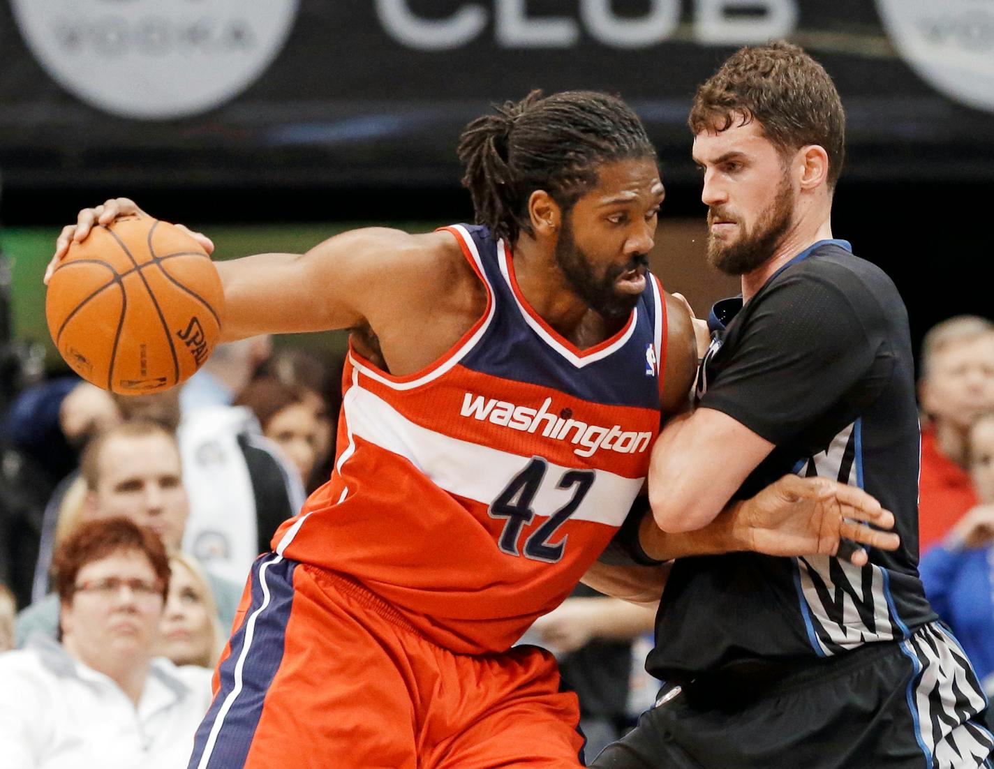 Minnesota Timberwolves' Kevin Love, right, slows Washington Wizards' Nene Hilario on a drive during the first quarter of an NBA basketball game, Friday, Dec. 27, 2013, in Minneapolis. (AP Photo/Jim Mone)