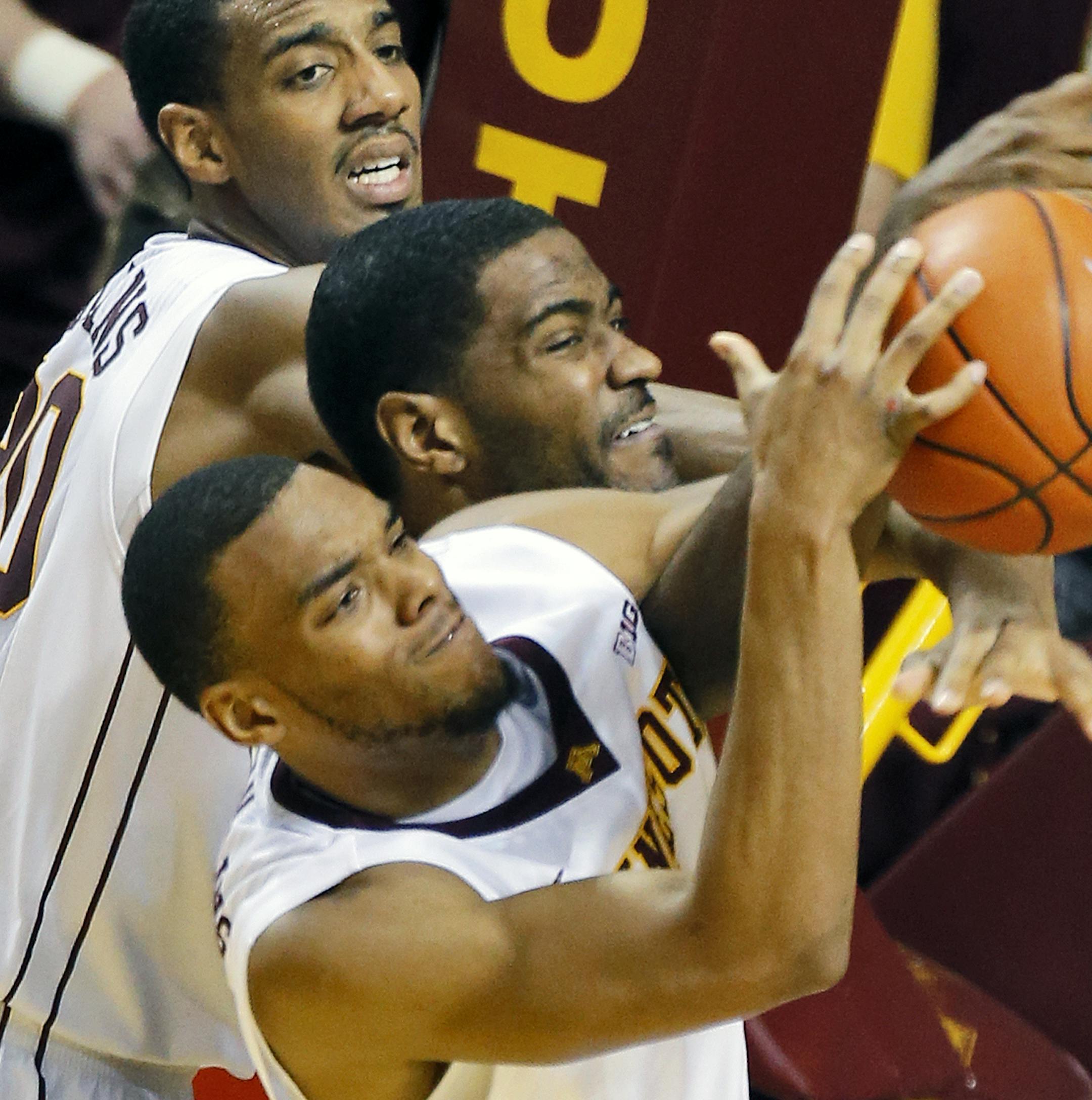Minnesota Gophers mens basketball vs. Purdue. Minnesota won 82-79. Minnesota's Autin Hollins, top, and Andre Hollins, bottom, defensively sandwiched Purdue's Rapheal Davis as they controled a 2nd half rebound. (MARLIN LEVISON/STARTRIBUNE(mlevison@startribune.com)