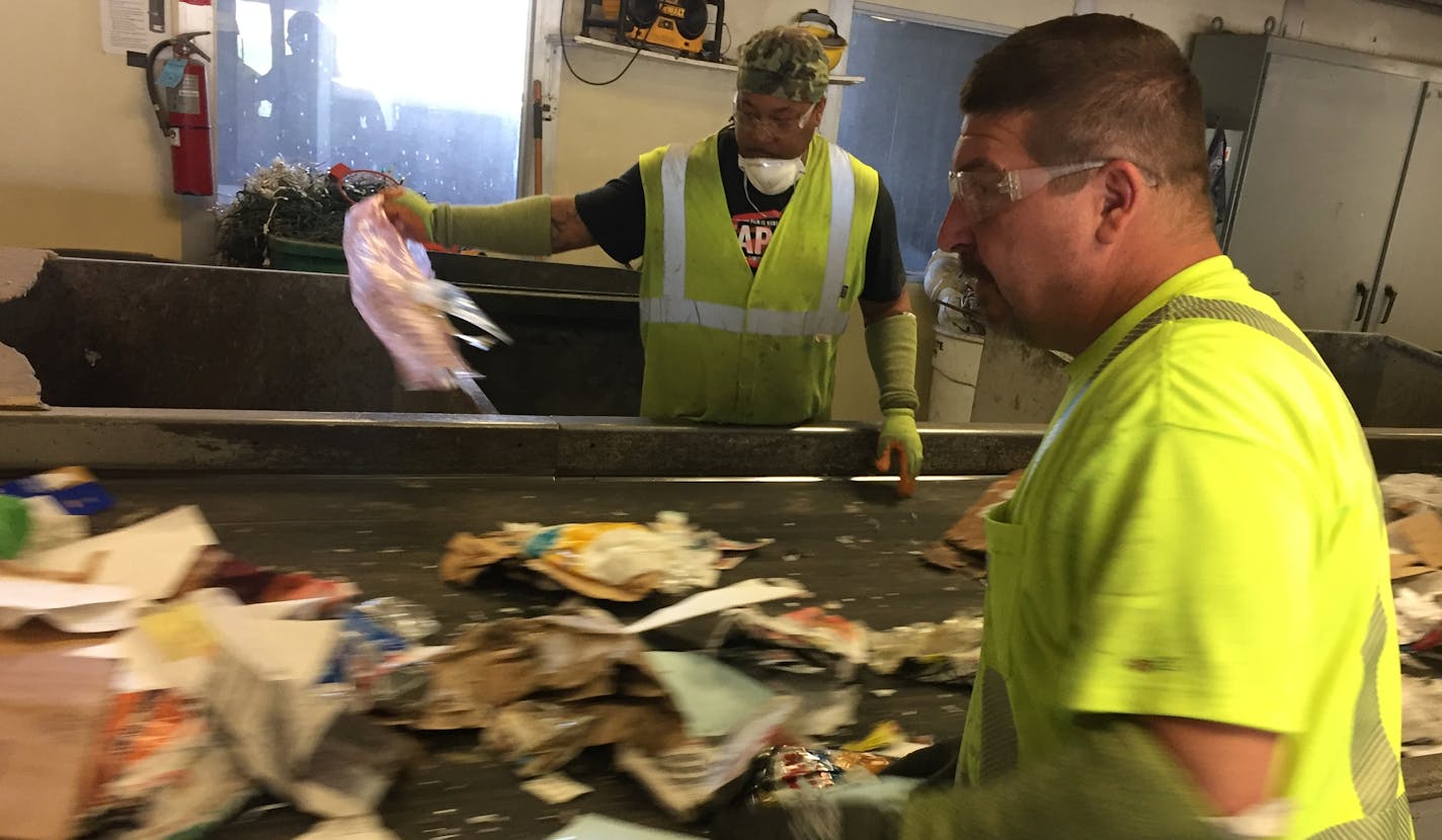 Workers at Dem-Con's recycling center in Shakopee remove non-recyclable items before they enter the sorting machines.