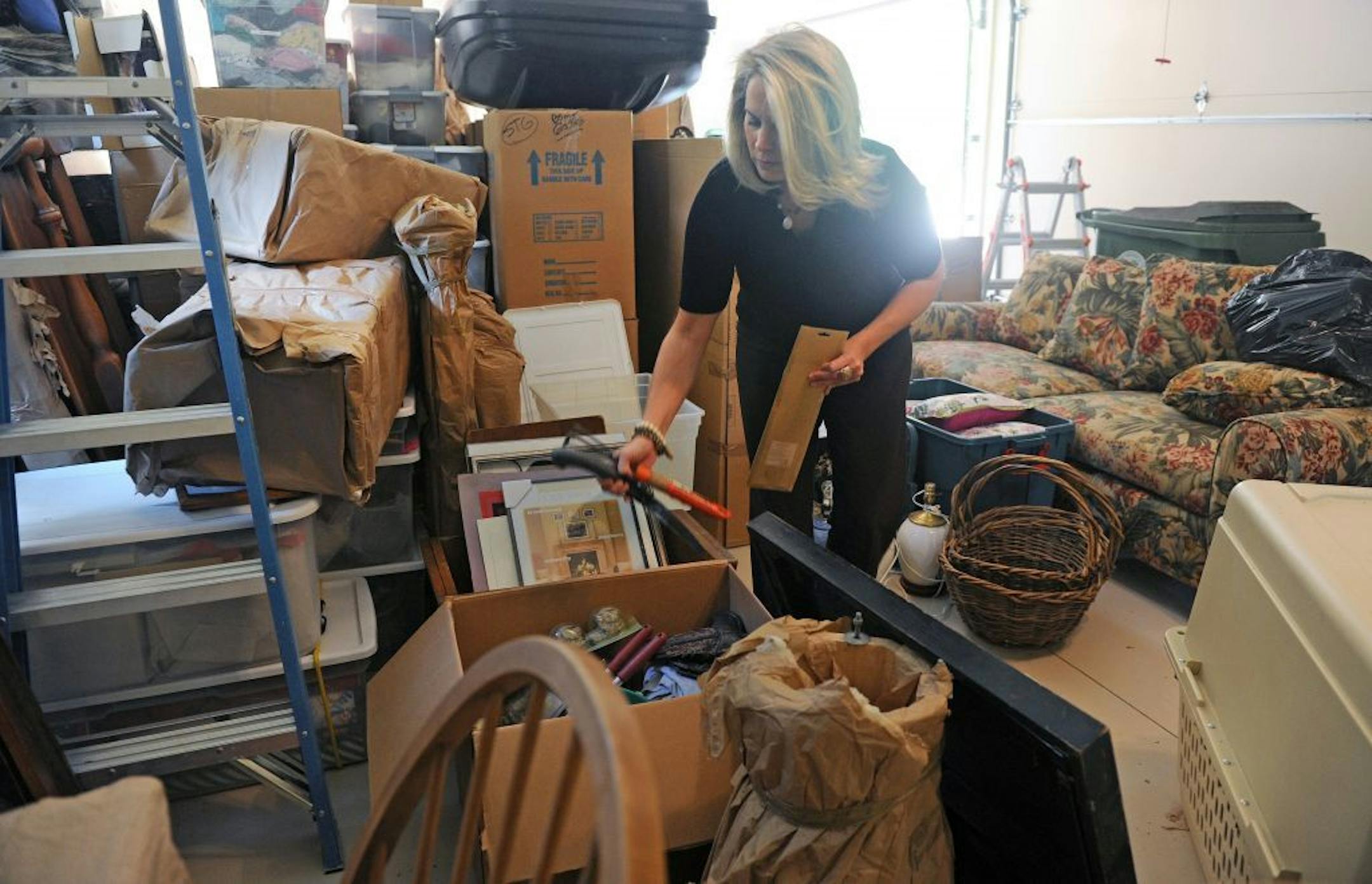 Certified professional organizer Sara Fisher goes through items brought over from a storage space at a client's home in Atlanta, Georgia, Wednesday, June 6, 2012.