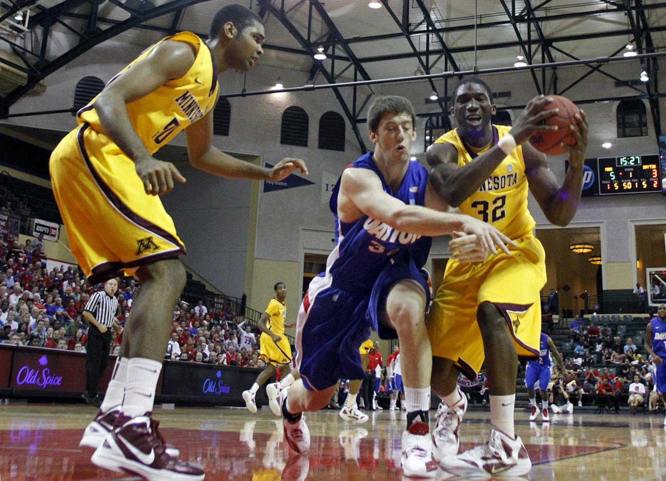 Gophers forward Trevor Mbakwe (32) fought for a rebound with Dayton's Matt Kavanaugh, center, as Gophers center Ralph Sampson III looked on. Mbakwe later hurt his right knee and is out for the season.