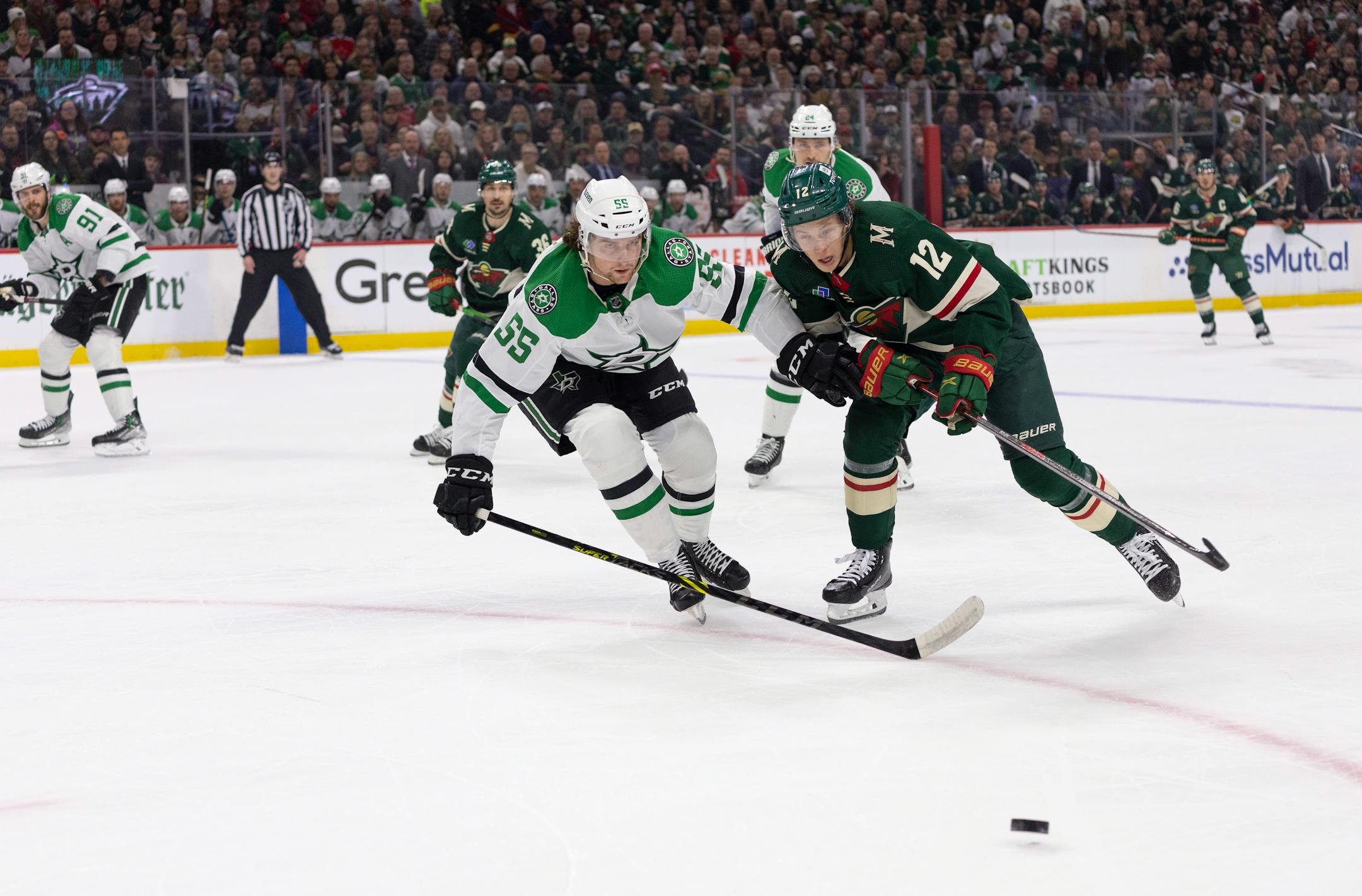 Dallas Stars defenseman Thomas Harley (55) and Minnesota Wild left wing Matt Boldy (12) chased a loose puck in the first period.