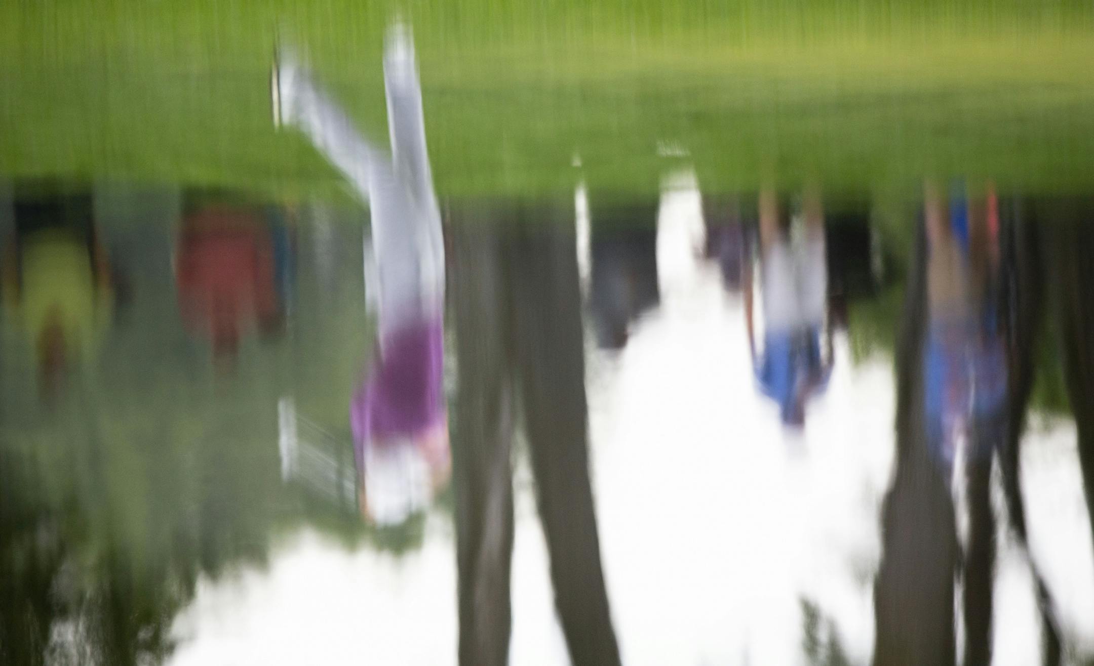 Sam Burns is reflected in the water hazard on the 18th fairway.