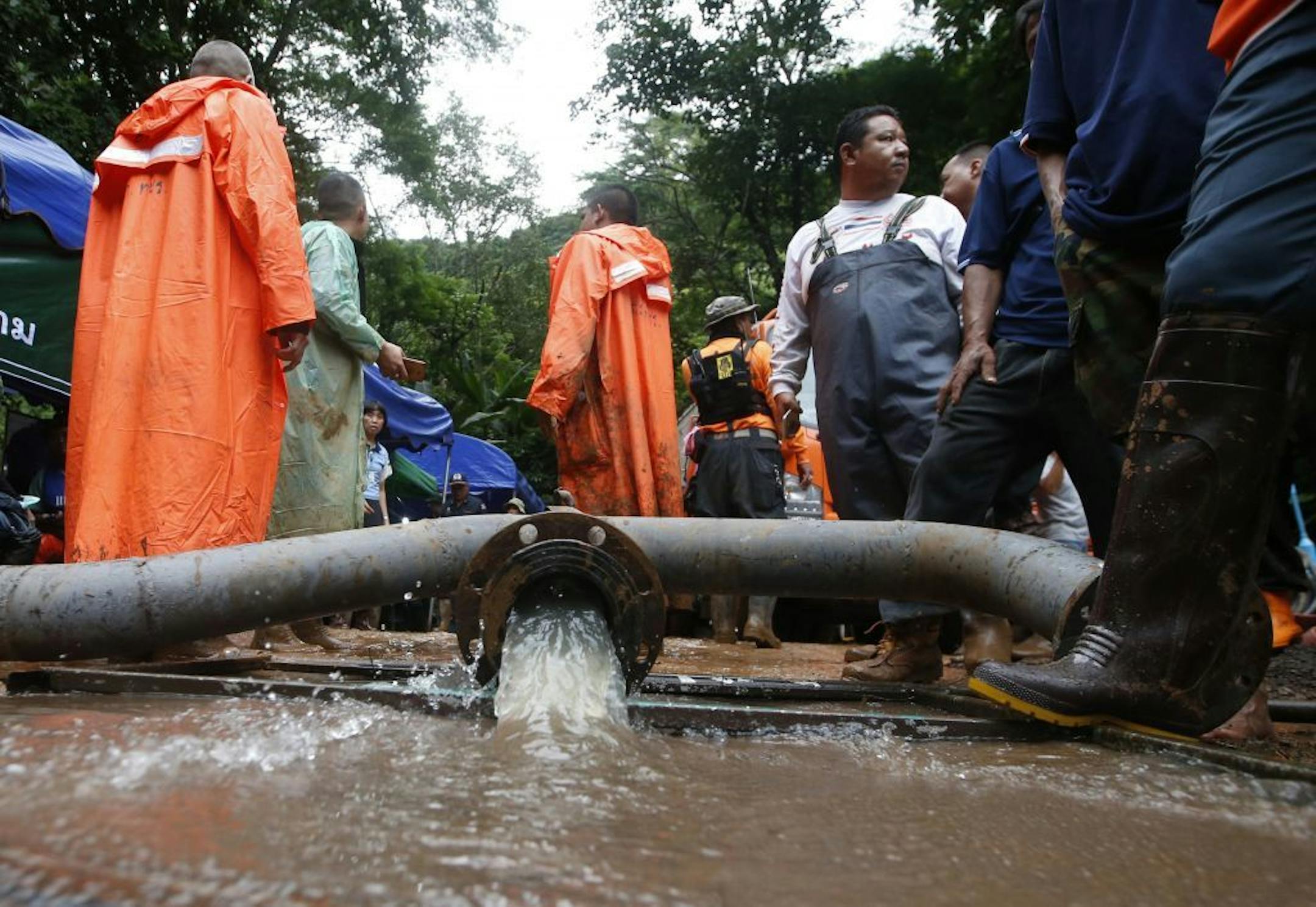 Water is pumped from a flooded cave that a soccer team and their coach believed to be missing in, Wednesday, June 27, 2018, in Mae Sai, Chiang Rai province, in northern Thailand. Rain is continuing to fall and water levels keep rising inside a cave in northern Thailand, frustrating the search for 12 boys and their soccer coach who have been missing since Saturday.