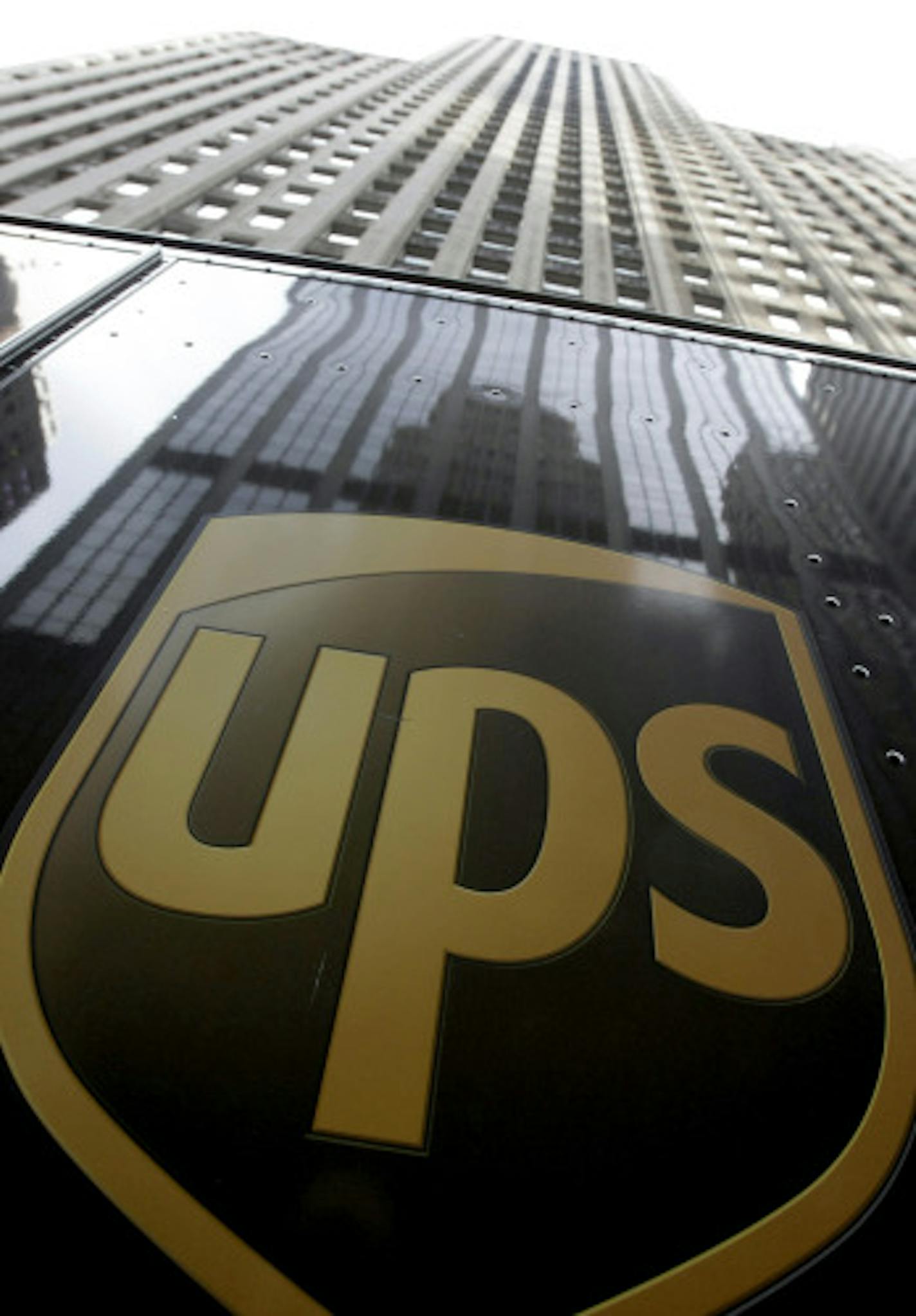 A UPS truck sits in front of a Chicago office building as the driver makes his deliveries Thursday, Oct. 23, 2008. UPS Inc.'s third-quarter profit fell nearly 10 percent despite a rise in sales, the world's largest shipping carrier said Thursday as it warned that it faces more challenges ahead, job cuts may be on the horizon and the "scope and the size" of a deal it is working out to carry some packages for rival DHL could change.