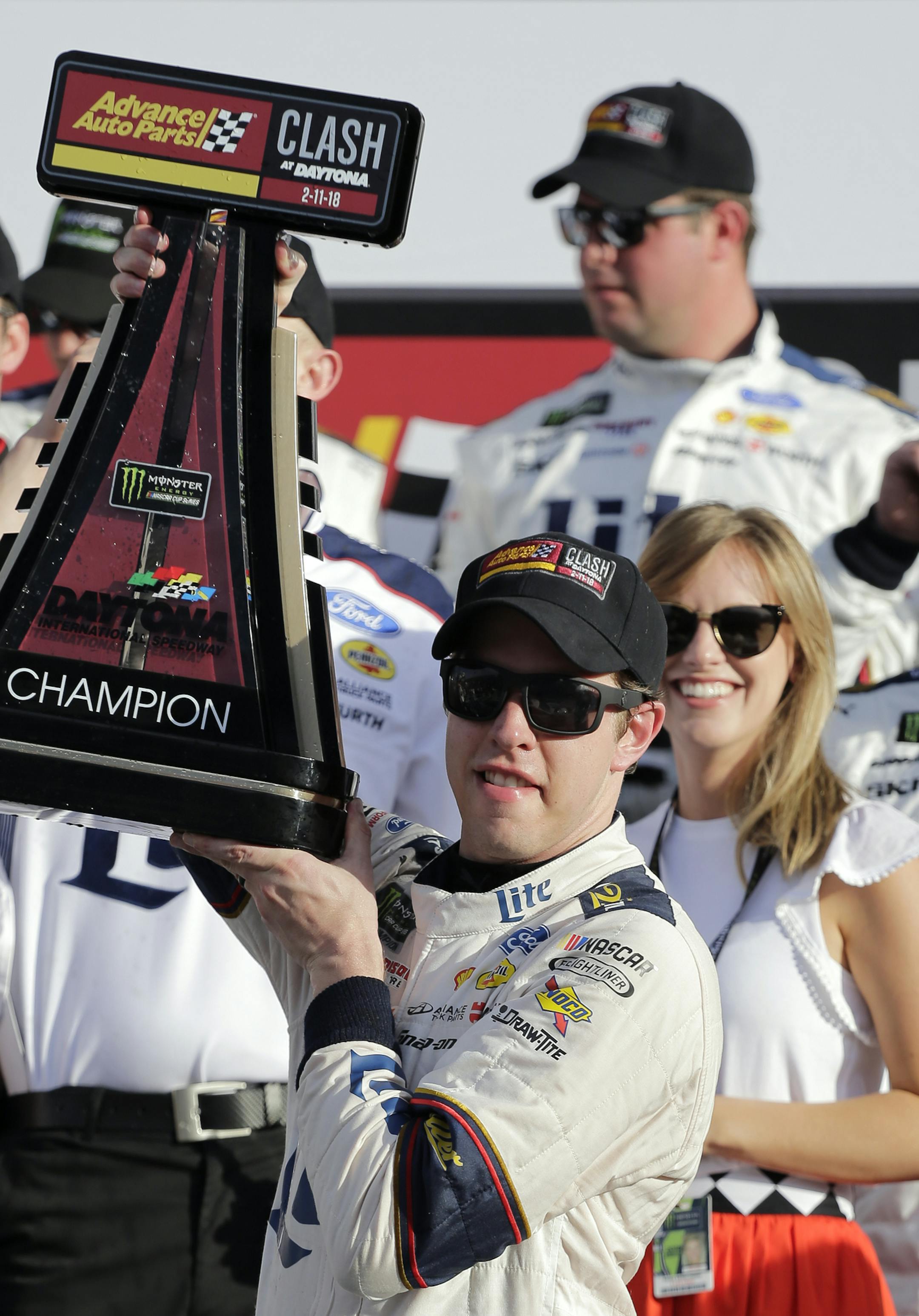 Brad Keselowski hold up his trophy after winning the NASCAR Clash auto race as his wife, Paige White, right, looks on, at Daytona International Speedway, Sunday, Feb. 11, 2018, in Daytona Beach, Fla. (AP Photo/Terry Renna)