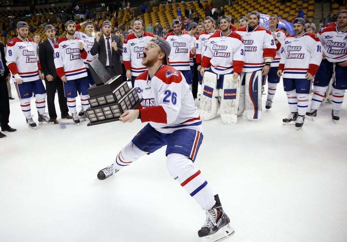 Massachusetts-Lowell's Christian Folin (26) holds the trophy after Lowell defeated New Hampshire 4-0 in the Hockey East championship game in Boston, S