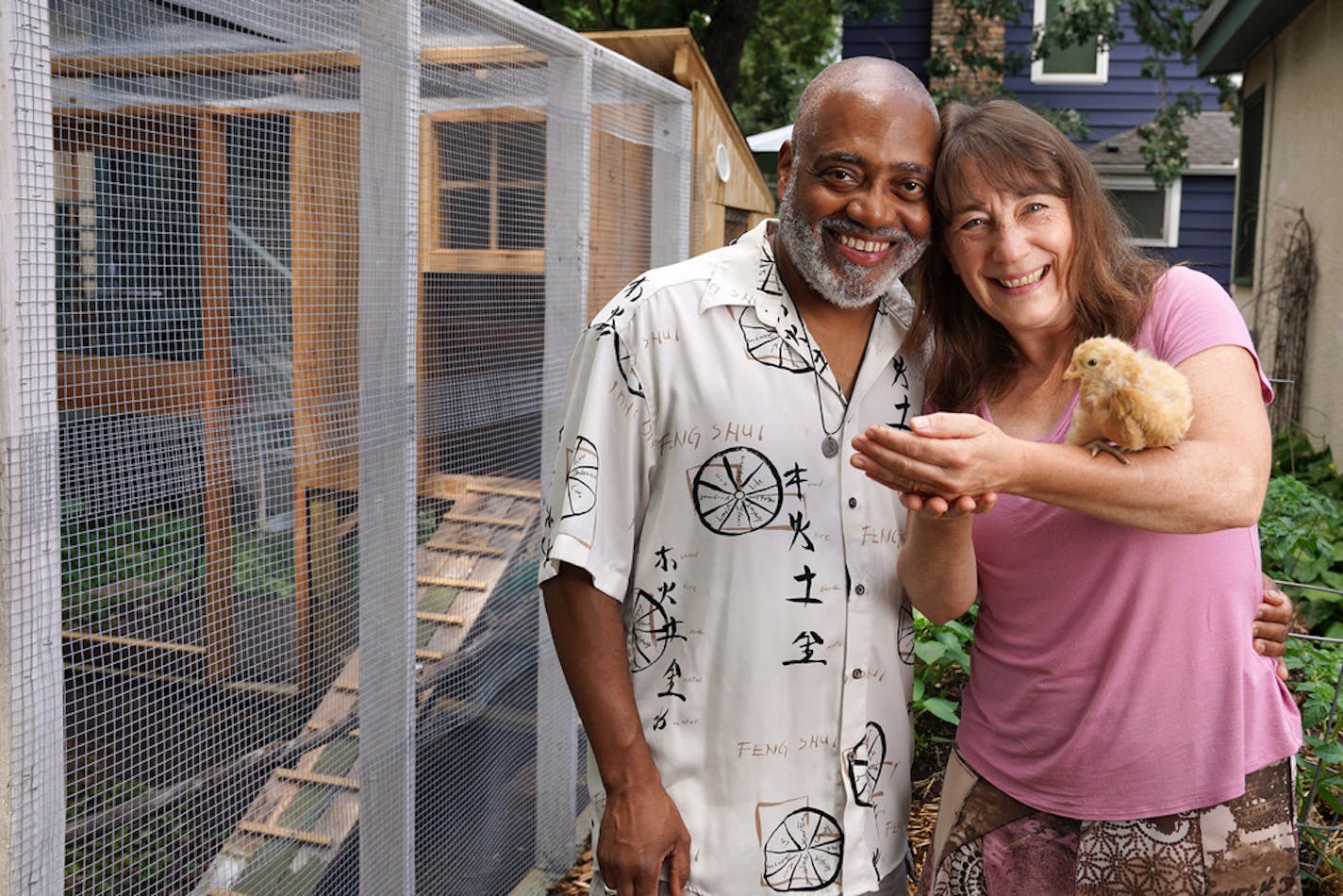 Classical musicians (and spouses) Bill Eddins and Jennifer Gerth with one of their chickens, Faye, near the elevated chicken coop and chicken run that Eddins built in their Minneapolis backyard.