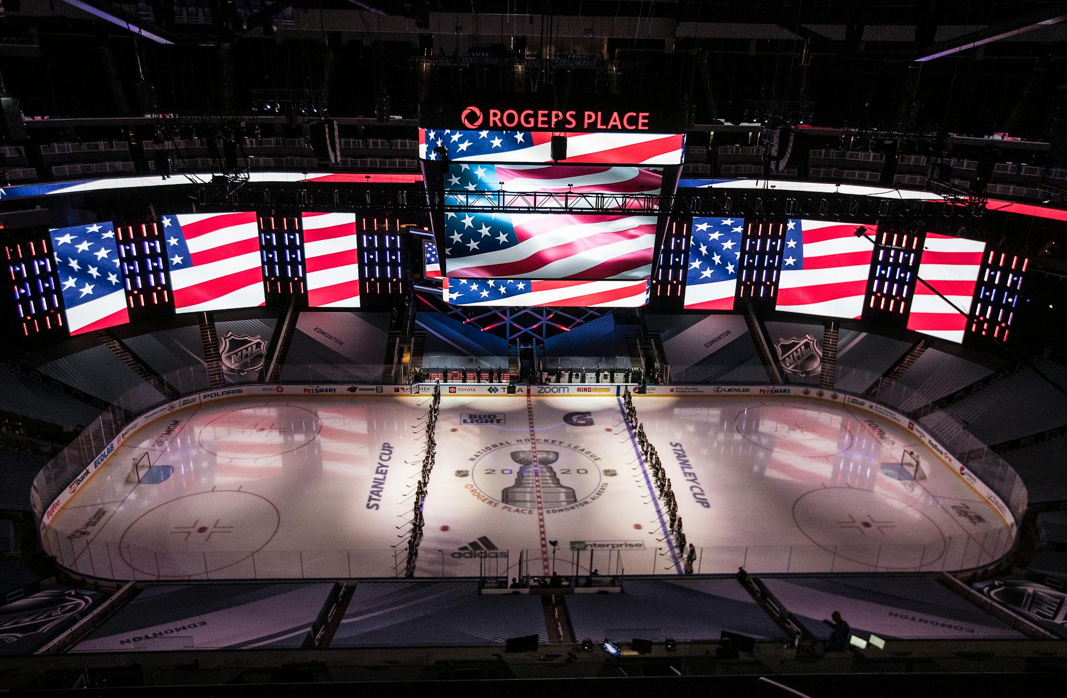 Colorado Avalanche and Minnesota Wild players stand for the national anthem during an exhibition game in Edmonton