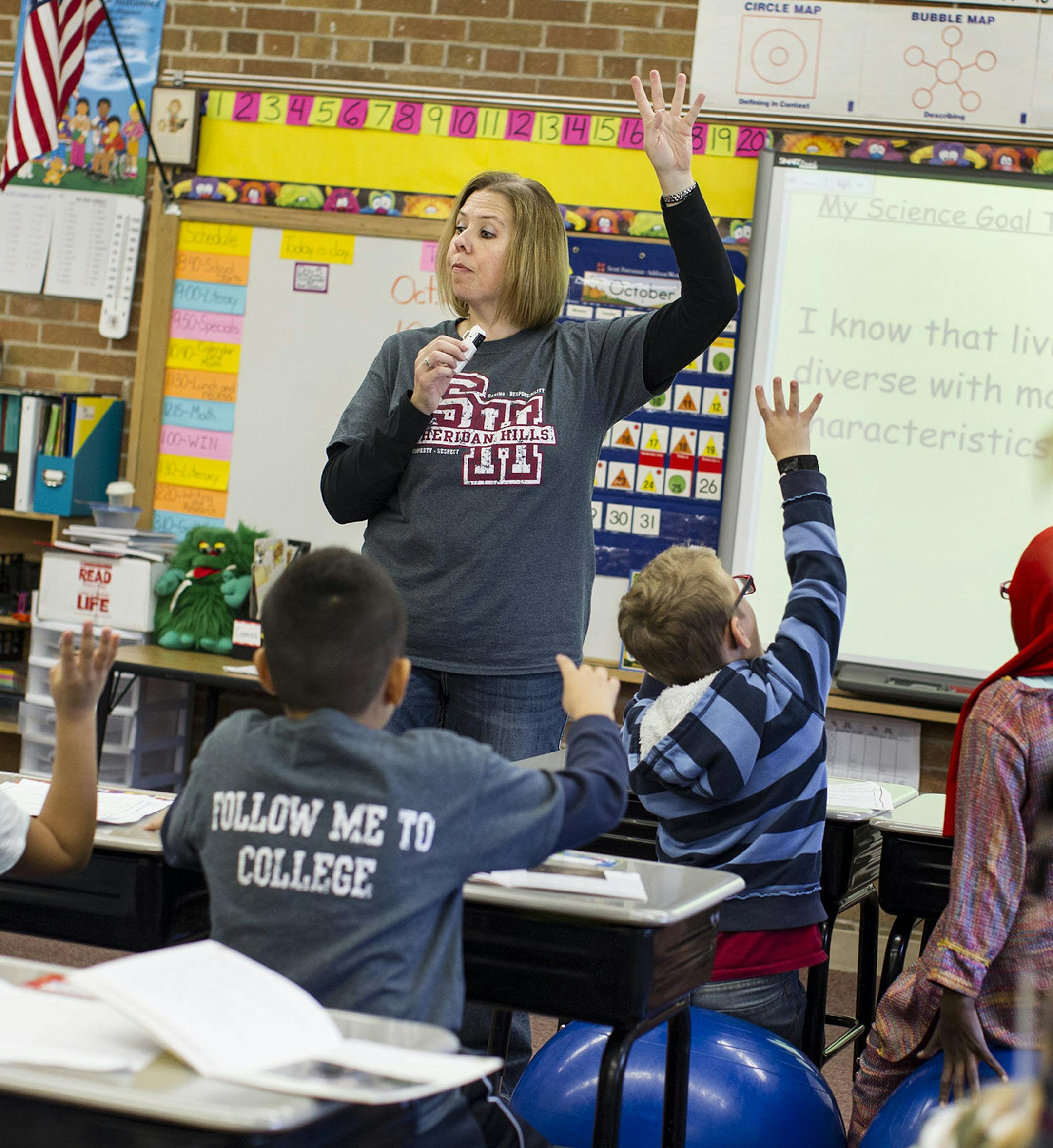 Classroom teacher Stacy Krohn, left, raises a hand to draw attention forward as ESL teacher Anne Hillman keeps an eye on the back of the room in Krohn's second and third grade split classroom at Sheridan Hills Elementary School in Richfield October 25, 2013. (Courtney Perry/Special to the Star Tribune) ORG XMIT: MIN1310251605242729