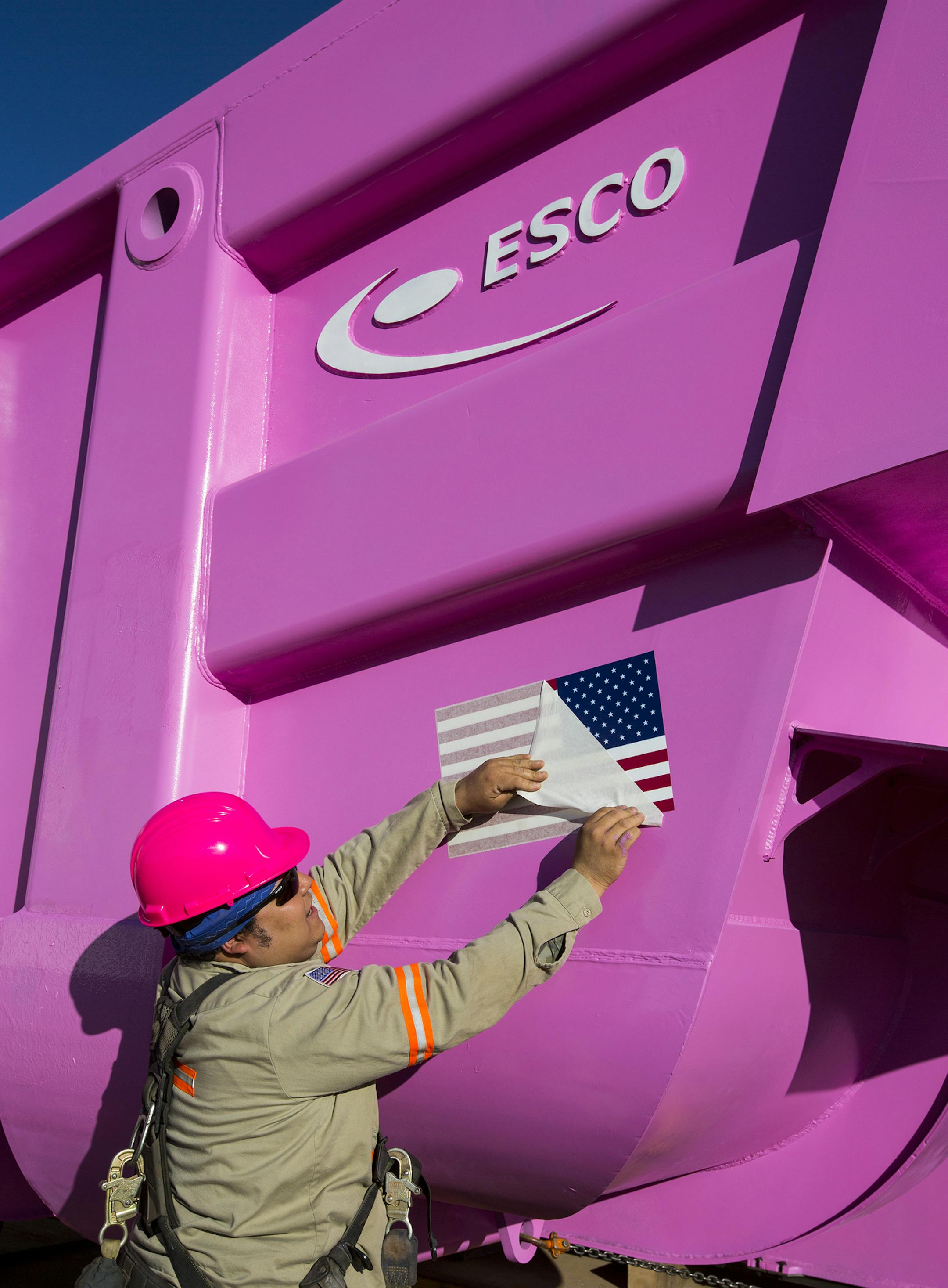 A Hibbing Taconite worker attached a large flag sticker to the side of the newly delivered truck bed.