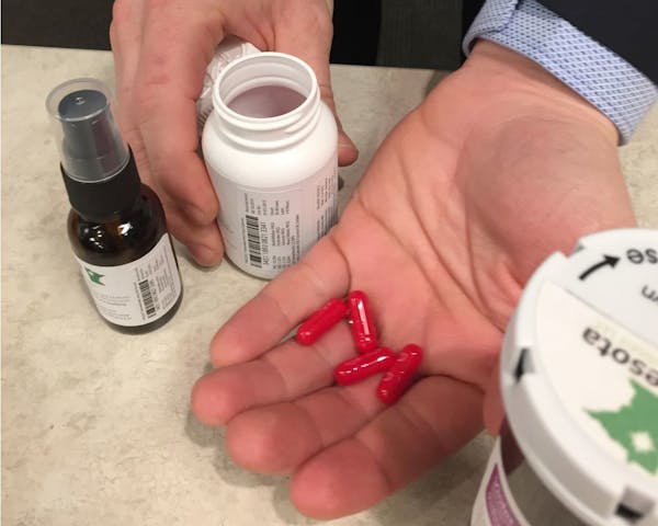 Jon Thompson of Minnesota Medical Solutions holds a sample of marijuana pills on Monday, Dec. 1, 2014 in St. Paul.
