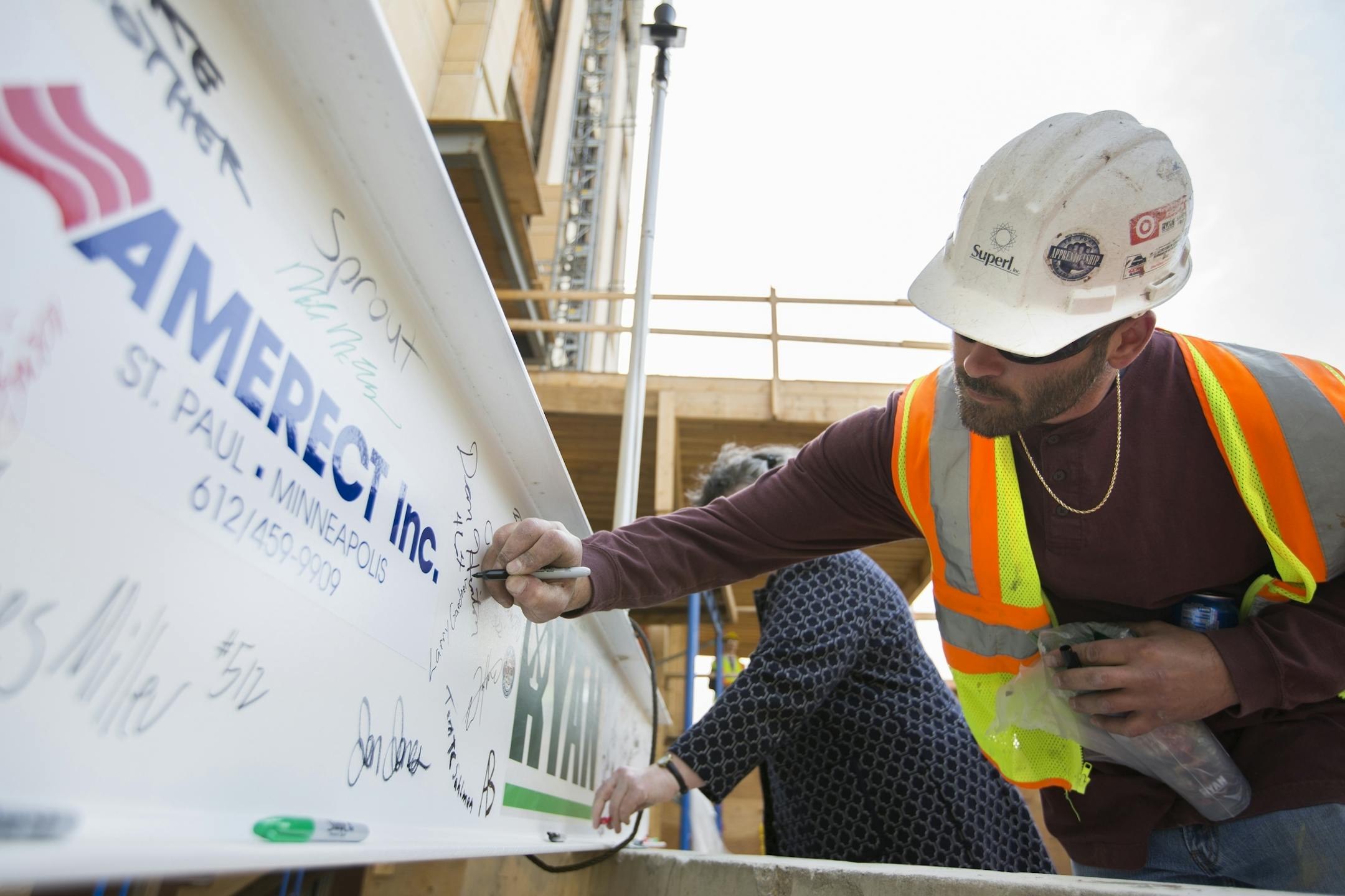 Larry Gardner, who installs fire insulation in the Wells Fargo towers, signs the steel beam before a topping off ceremony for the new Wells Fargo towers by Ryan Companies in Minneapolis on Tuesday, June 2, 2015.