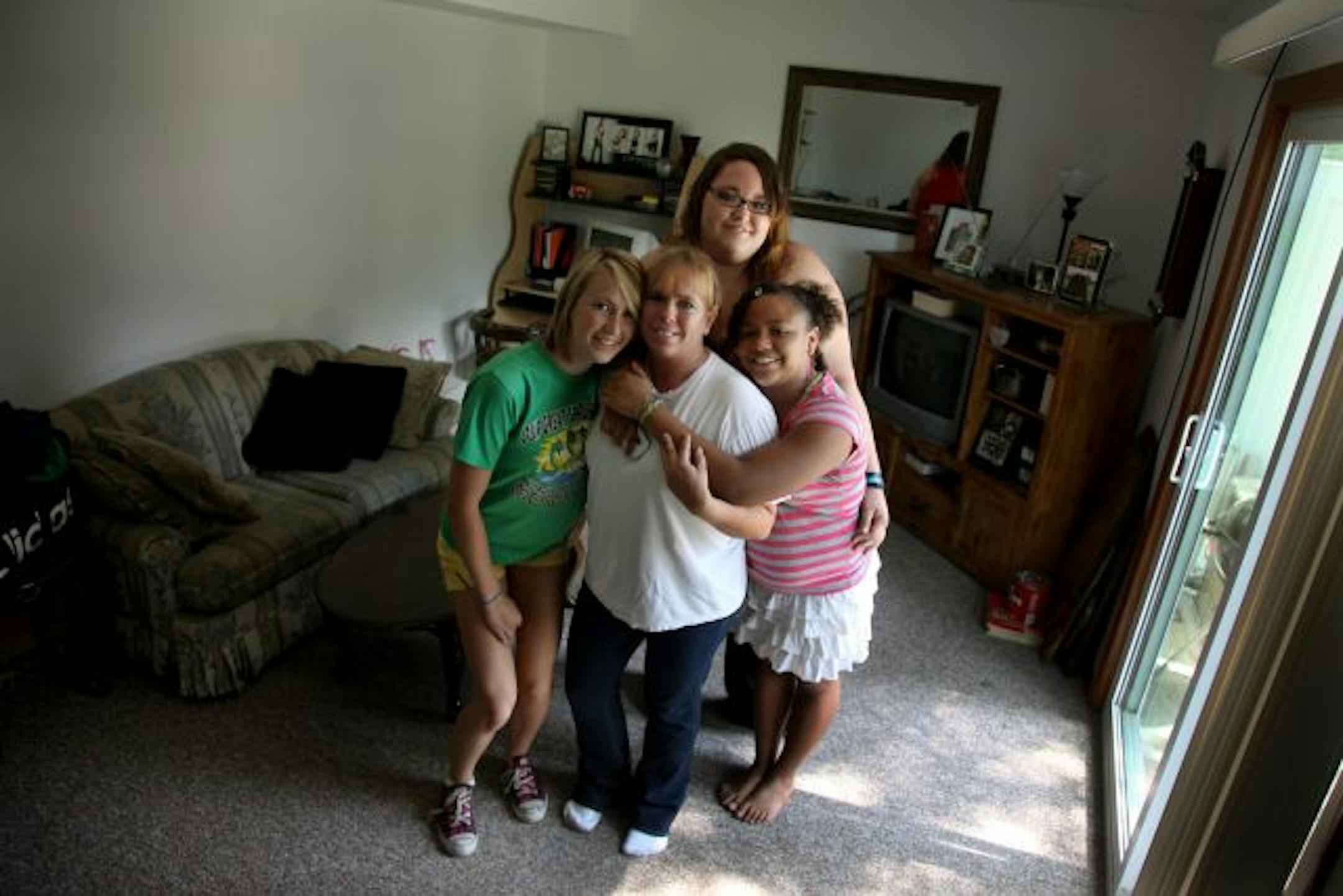Marsha White, center, was surrounded with a hug by her daughters, from left, Kayla White, 16, Krista White, 19, Lexi Wesley, 12, inside their townhome. White said that her home has new lighting fixtures, new central air, and new light fixtures.