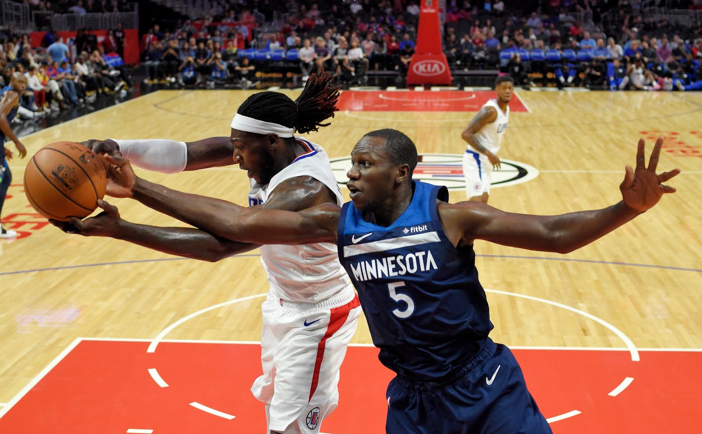 Wolves center Gorgui Dieng and Clippers forward Montrezl Harrell battled over a rebound during a preseason game. The Wolves have had trouble tracking down long rebounds on missed three-pointers.