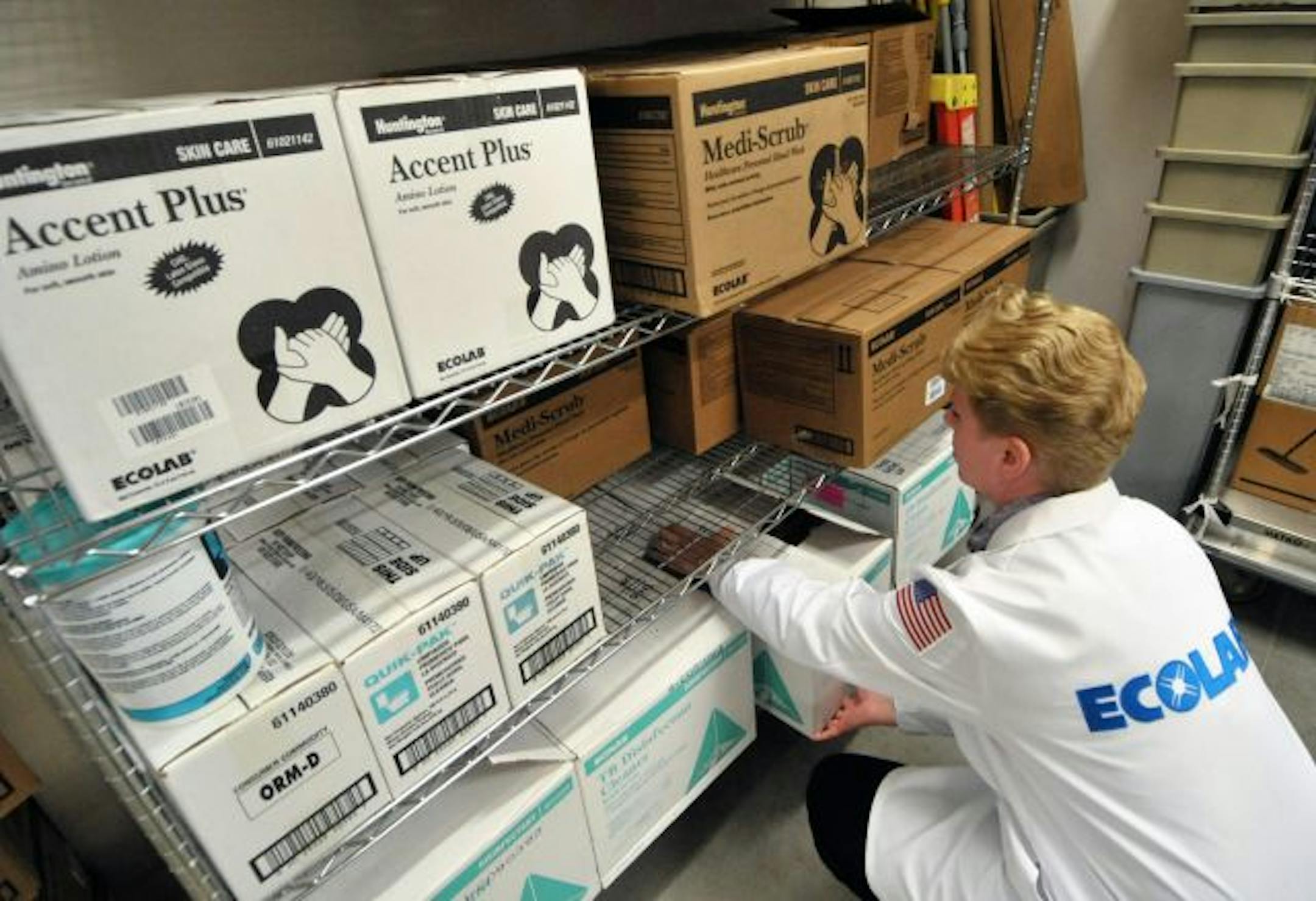 Ecolab's Donnell Slettedahl adjusted Ecolab products on storage shelves at Children's Hospital of Minneapolis.