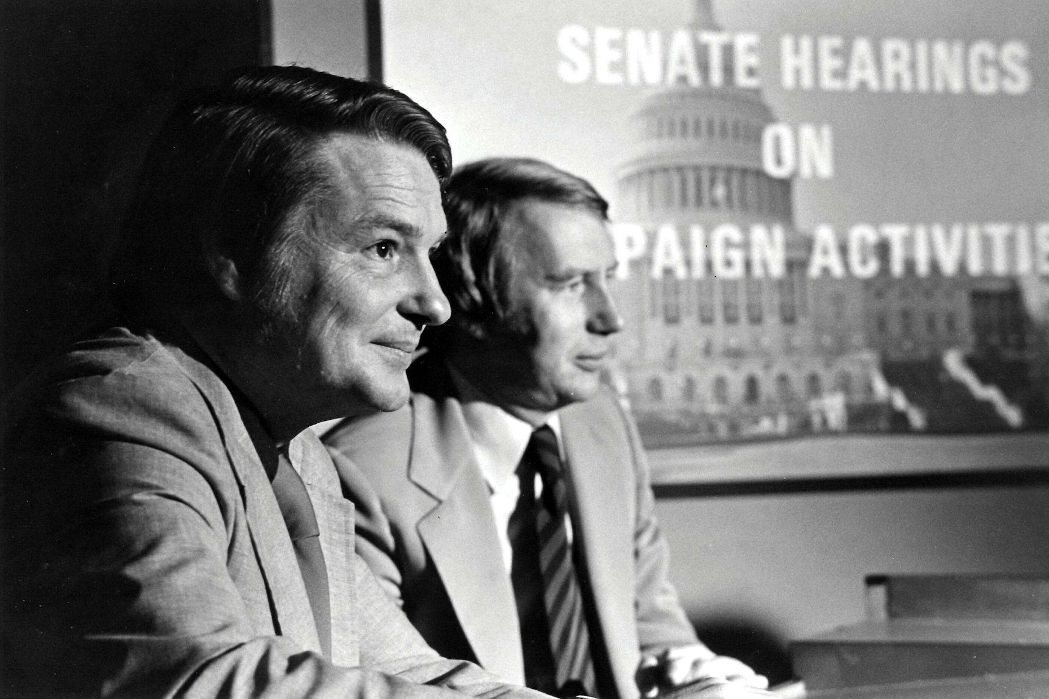 This 1973 image released by PBS shows co-anchors Jim Lehrer, left, and Robert MacNeil reporting on the Watergate hearings. PBS announced that Lehrer died Thursday, Jan. 23, 2020, at home. He was 85. (PBS via AP)