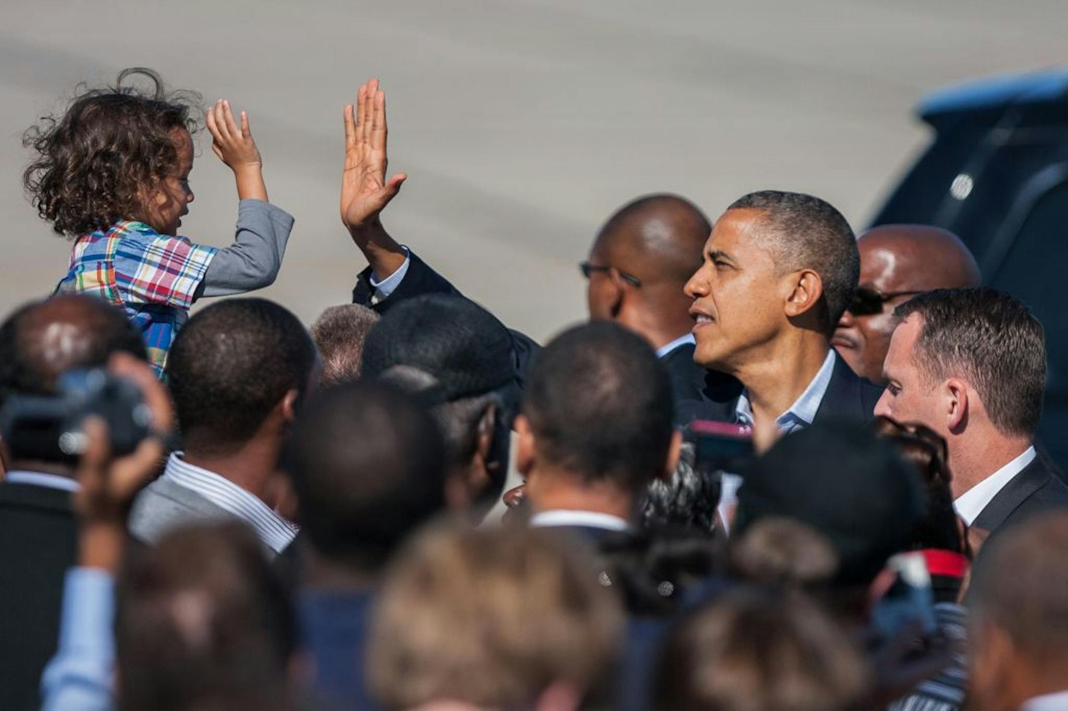 President Barack Obama high-fives with a child as he arrives at the Newport News/Williamsburg International Airport in Newport News, Va. on Saturday, Oct. 13, 2012.