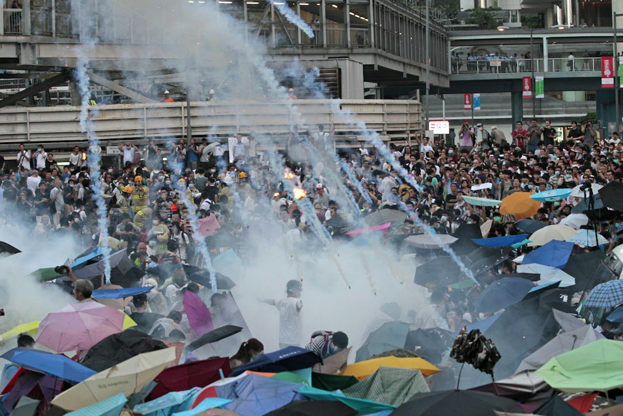 FOR USE AS DESIRED, YEAR END PHOTOS - FILE - Riot police launch tear gas into the crowd as thousands of protesters surround the government headquarters in Hong Kong Sunday, Sept. 28, 2014. Hong Kong police used tear gas and warned of further measures as they tried to clear thousands of pro-democracy protesters gathered outside government headquarters in a challenge to Beijing over its decision to restrict democratic reforms for the city. (AP Photo/Wally Santana, File)