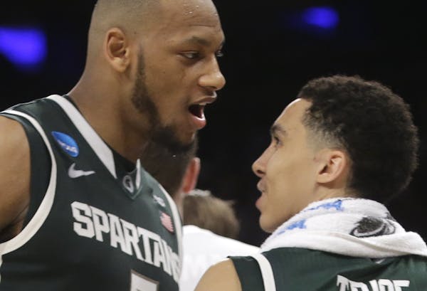 Michigan State's Adreian Payne, left, and Travis Trice celebrate after Michigan State defeated Virginia 61-59 in a regional semifinal of the NCAA men'
